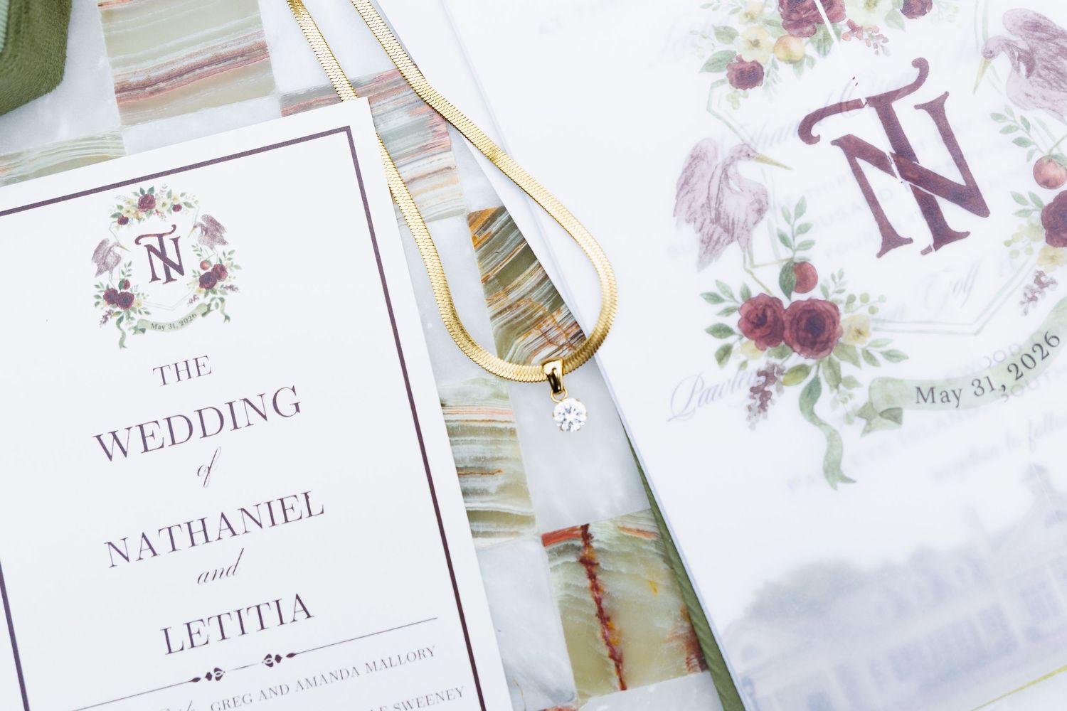 Elegant wedding stationery suite featuring floral crest design for Nathaniel and Letitia with gold necklace accent.
