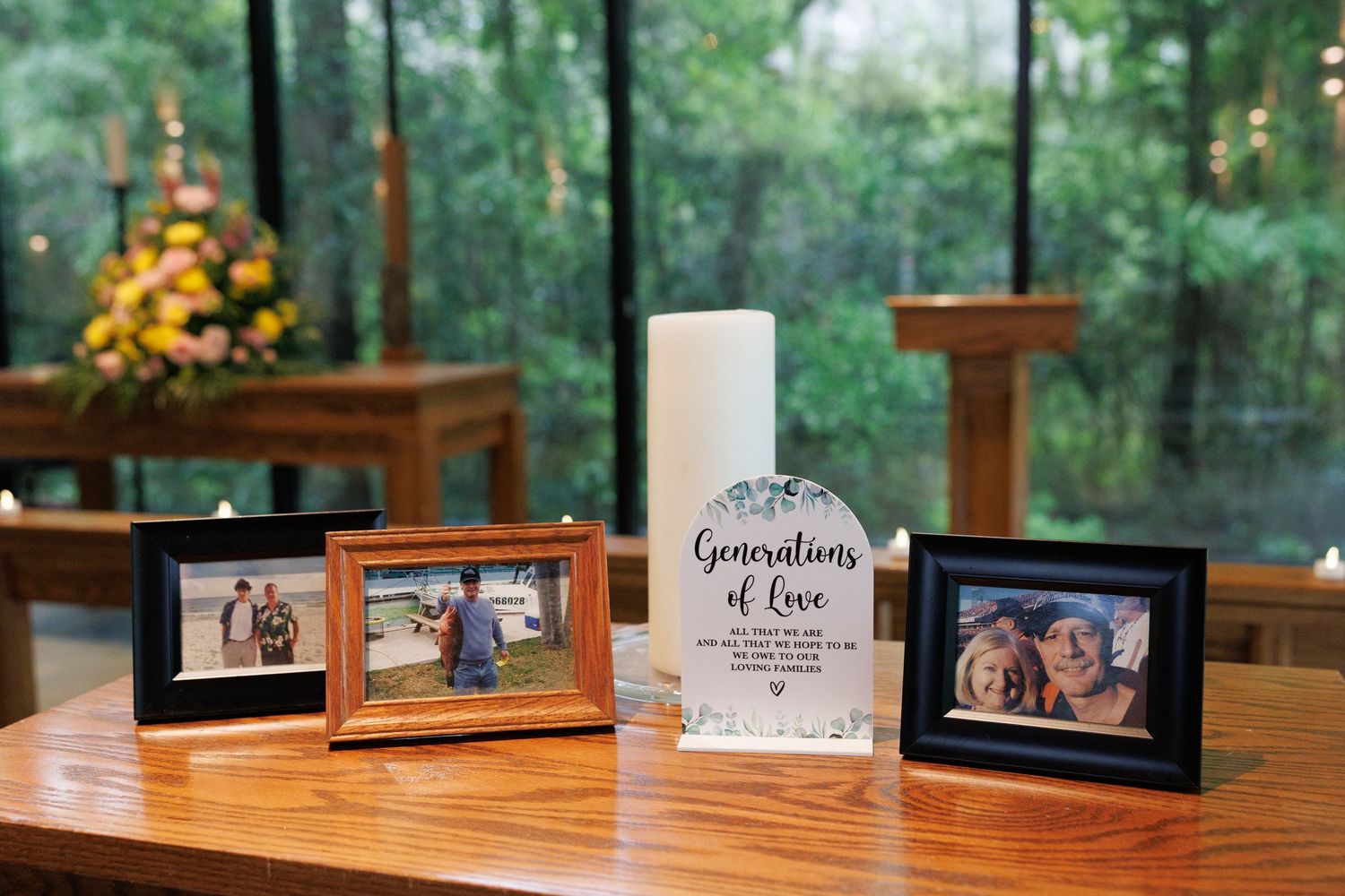 Wedding unity candle display with Generations of Love sign flanked by family photo frames on a wooden altar.