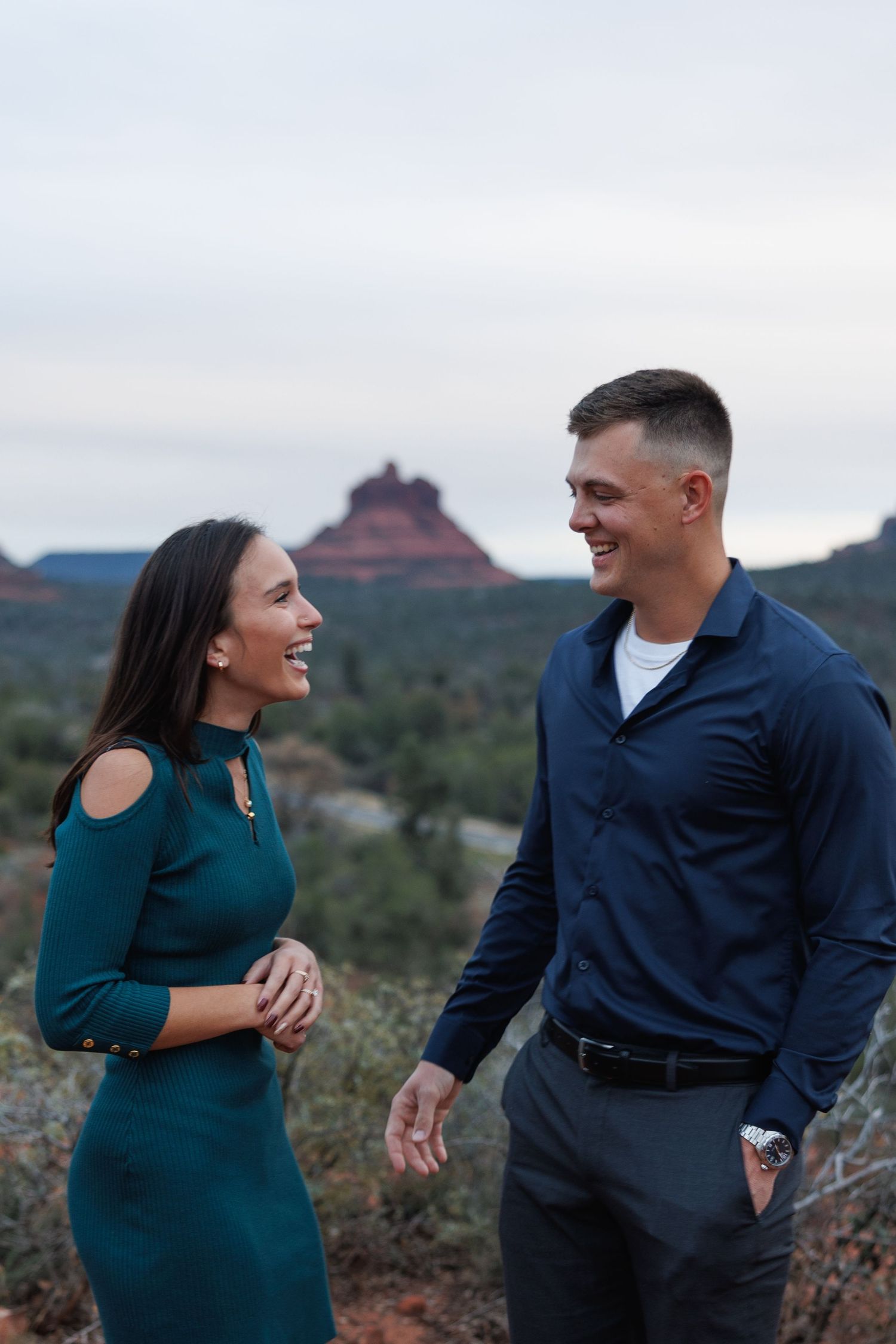 Happy couple laughing together with iconic Bell Rock butte in Sedona Arizona background.