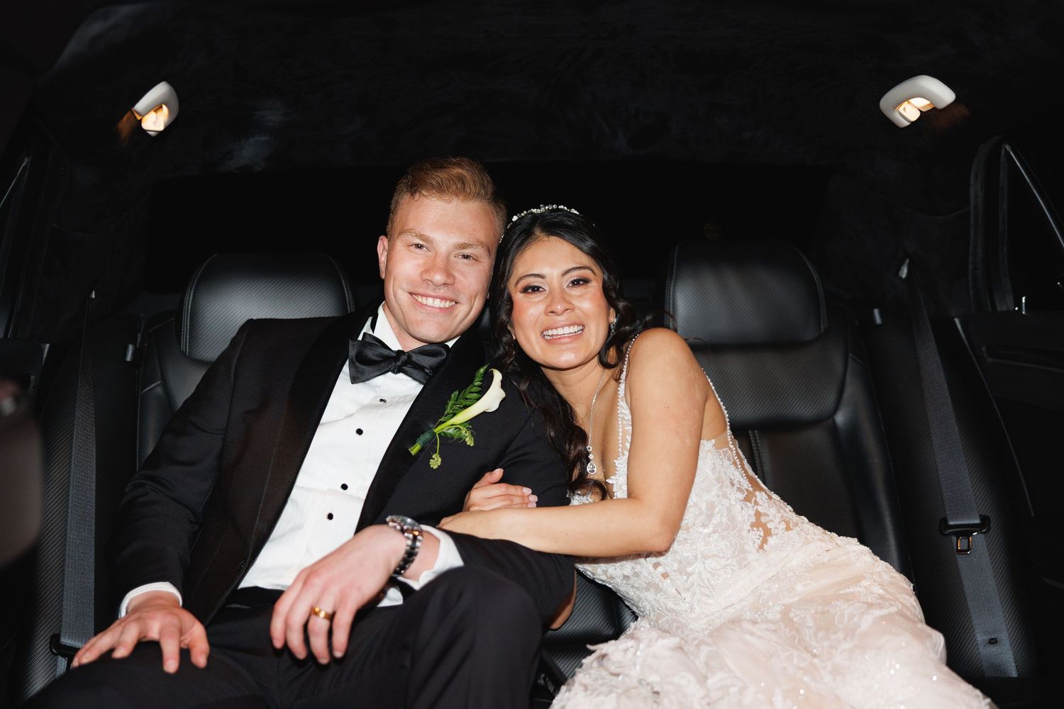Bride and groom smile together in the back of a limousine following their wedding celebration at The Yorkmont in Charlotte, North Carolina.
