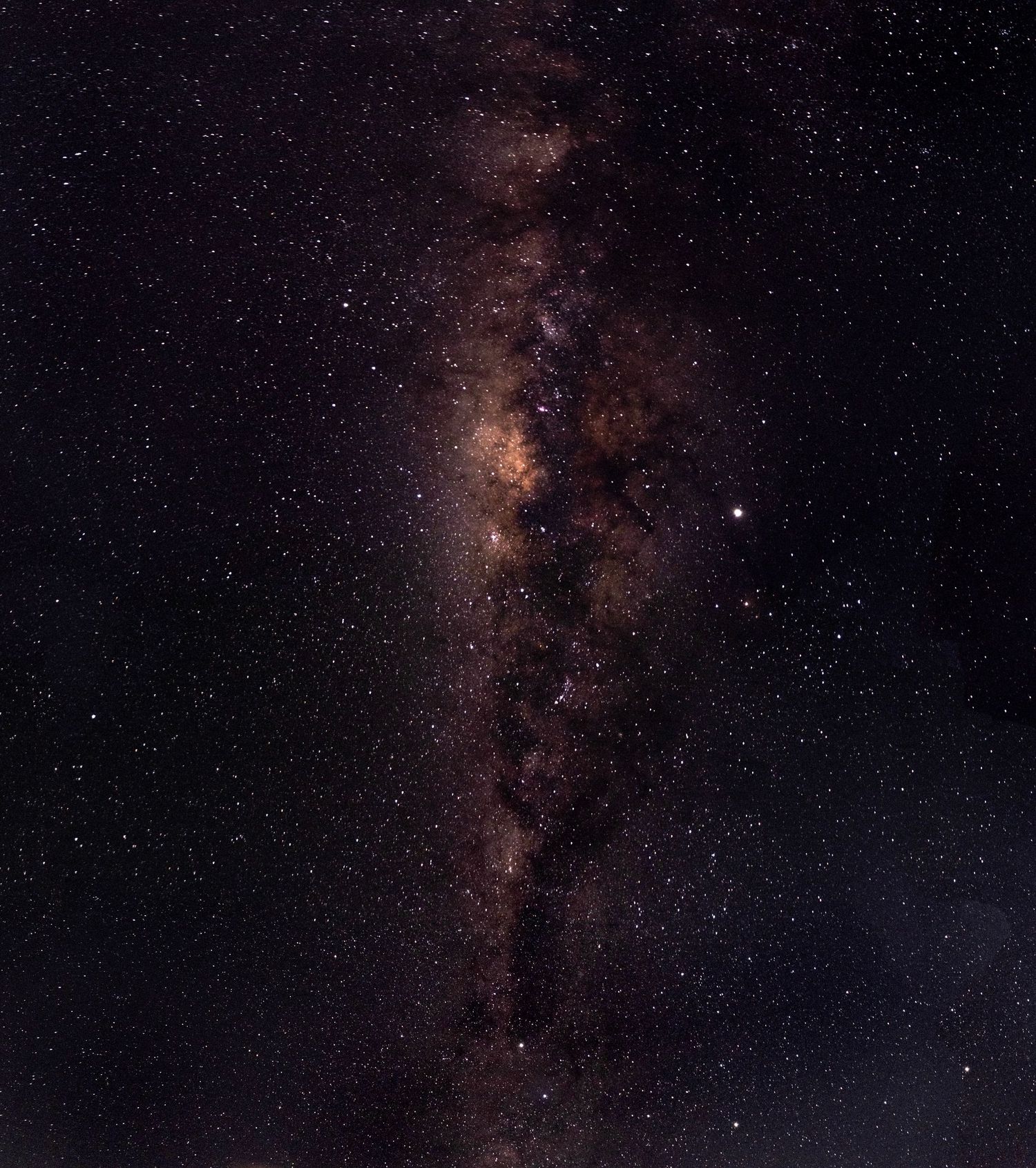Stunning Milky Way galaxy core rising vertically through a dark night sky filled with thousands of stars.