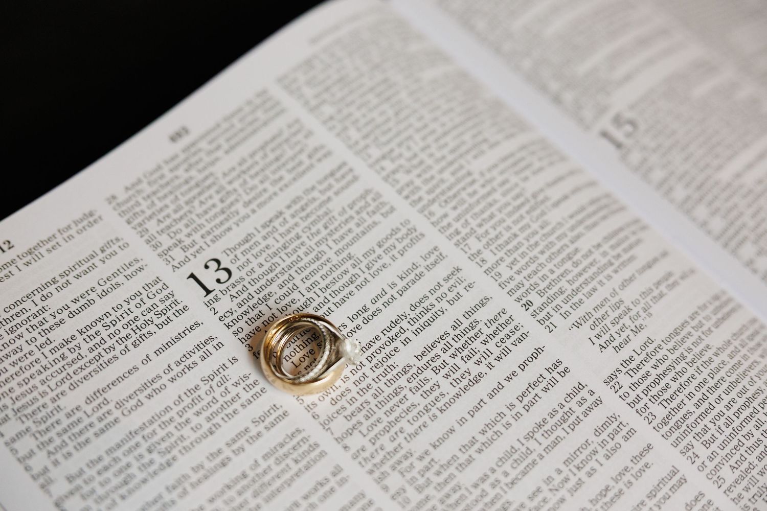 Gold wedding rings resting on an open Bible page, symbolizing faith and marriage commitment.