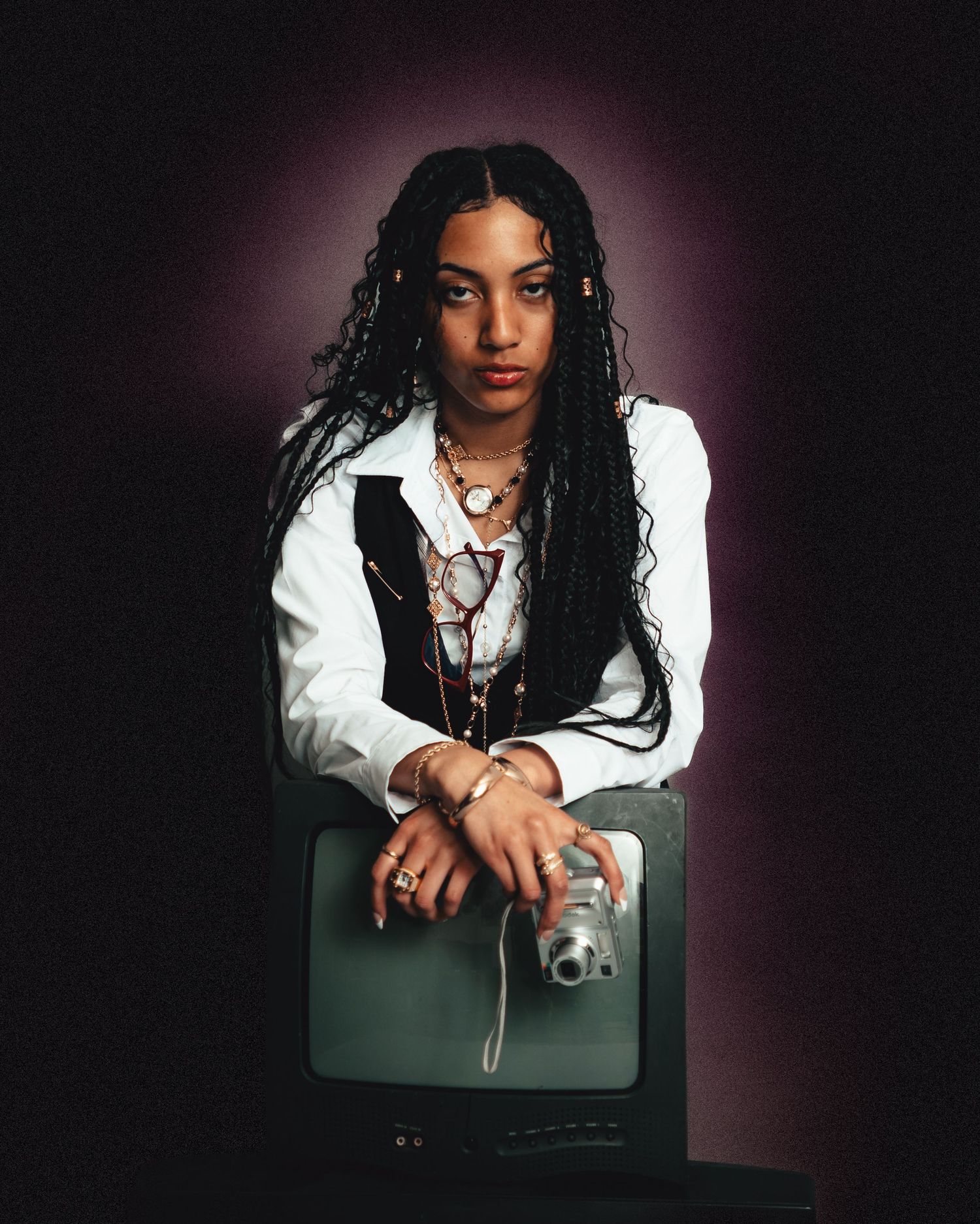 Artistic portrait series with dark moody lighting and vintage camera props.