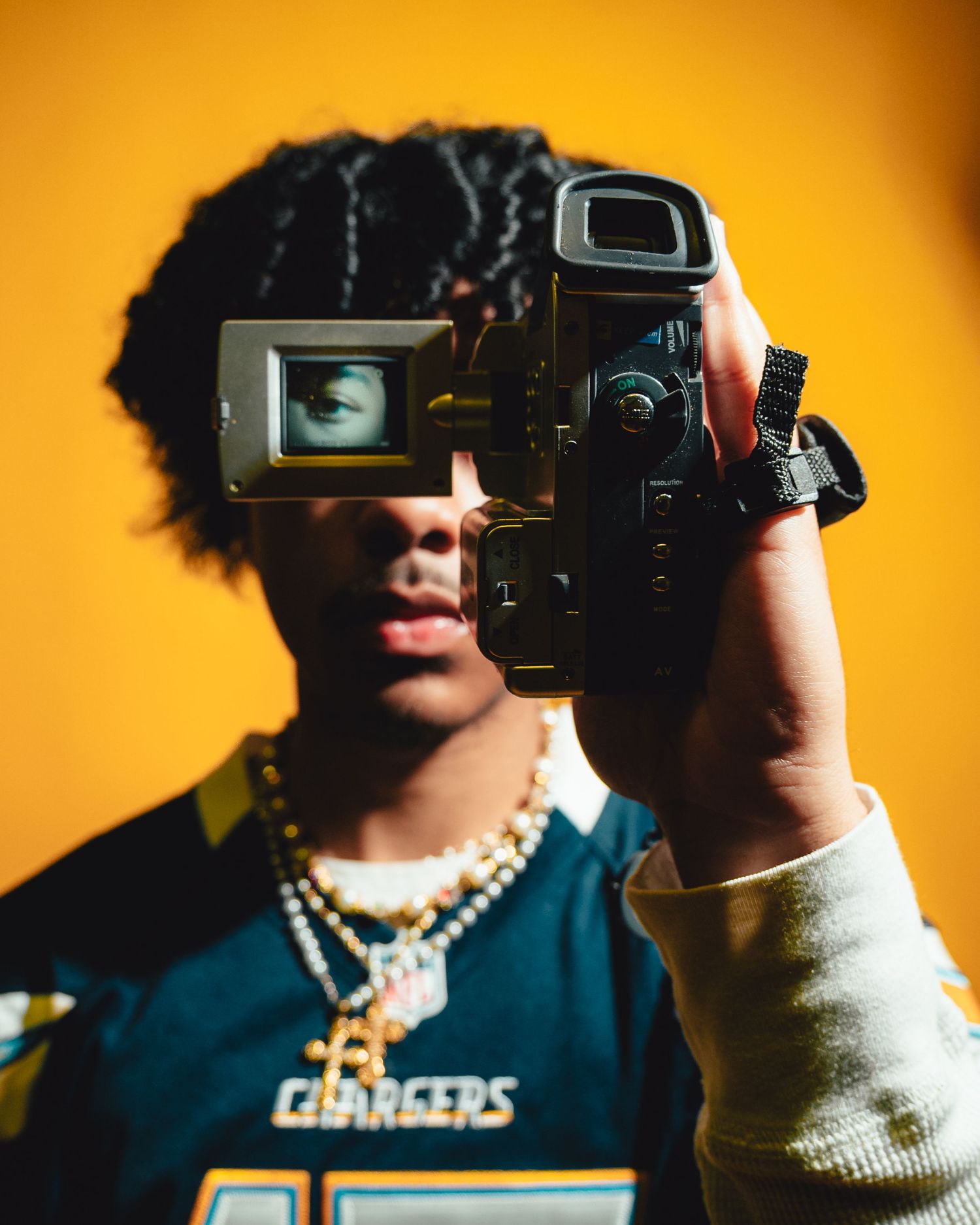 Series of shots with vintage video camera against orange background.