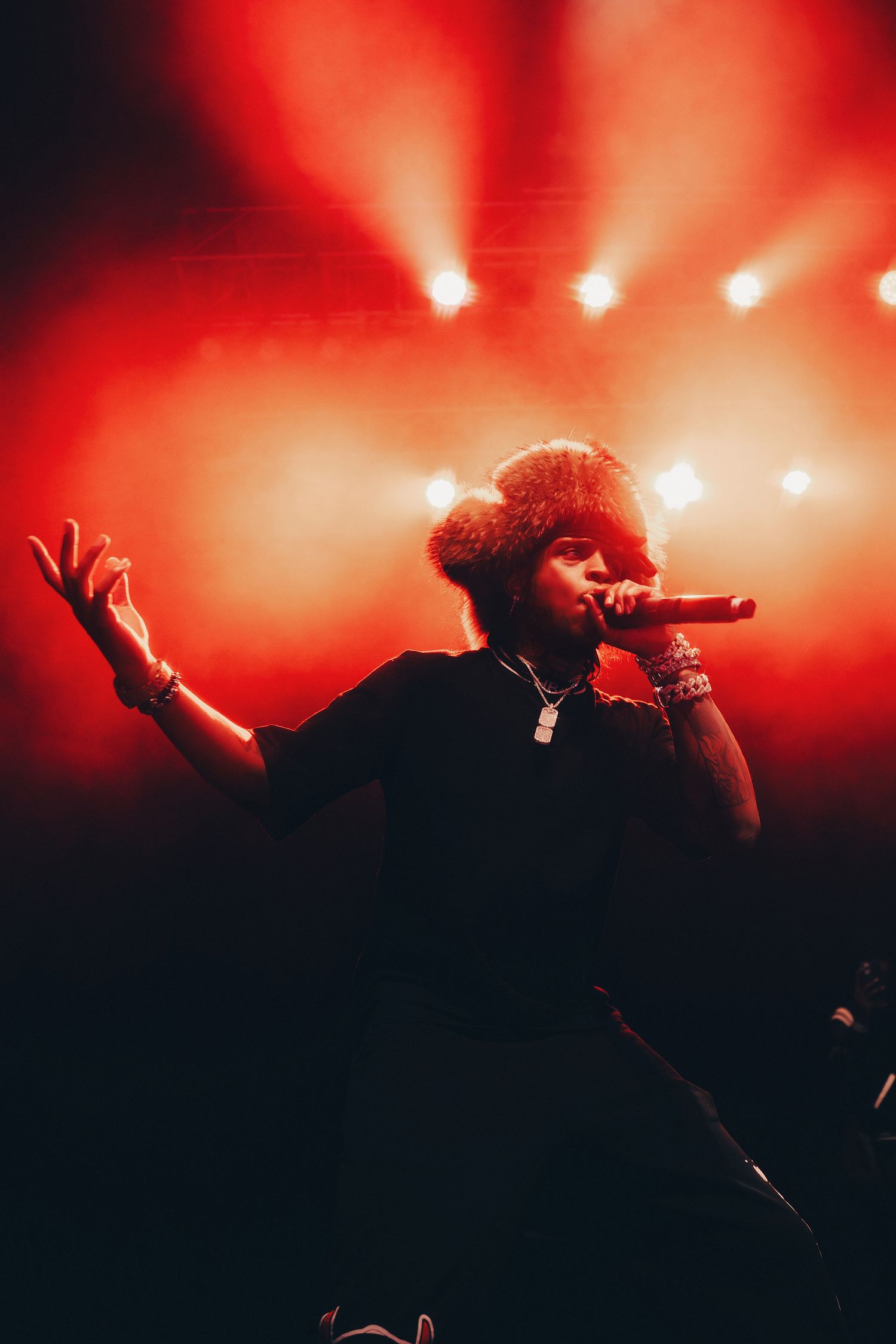 Silhouetted performer on stage with dramatic red lighting and smoke effects.