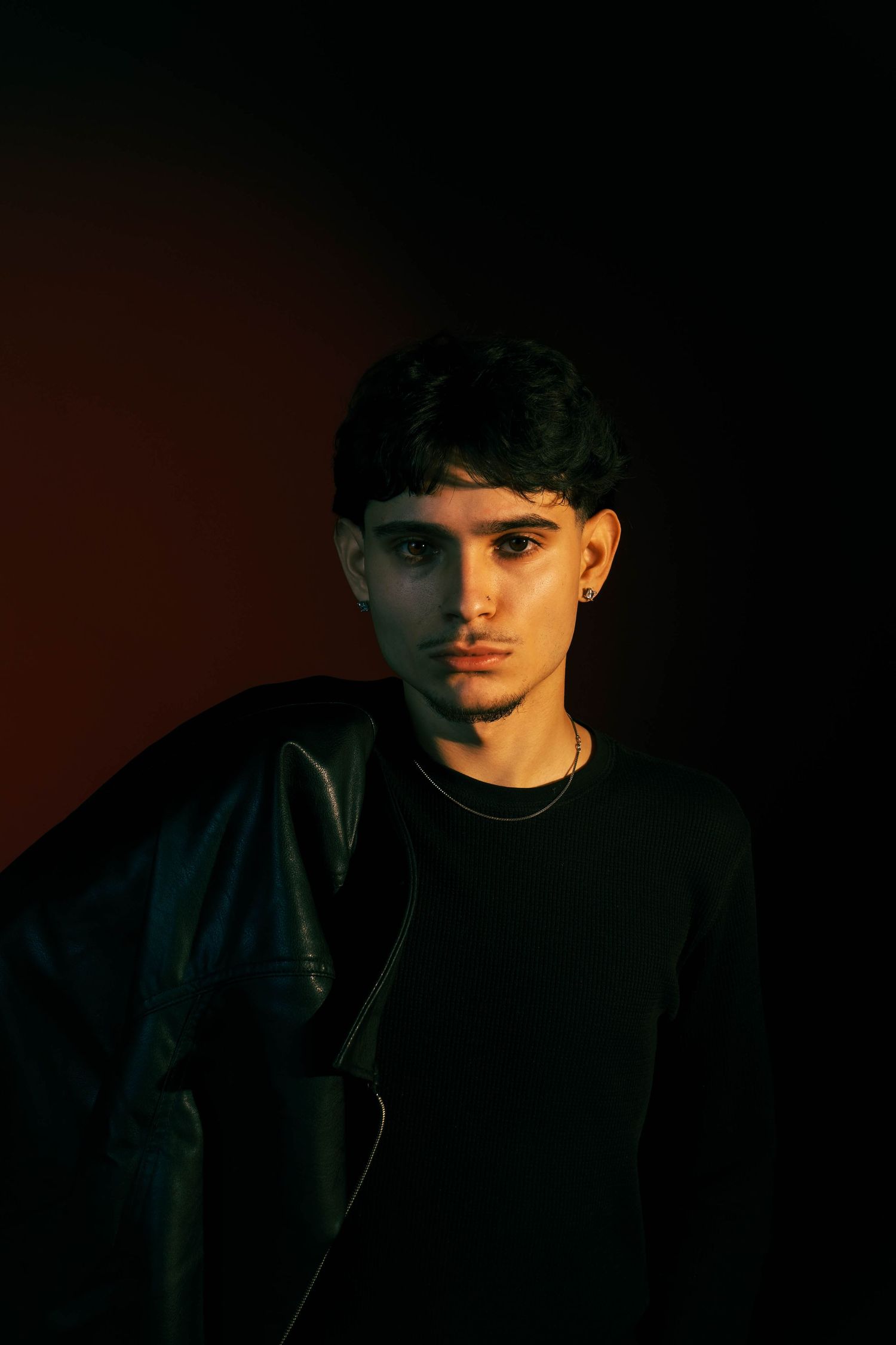 Dramatic portrait series in dark lighting with strong shadows creating a moody atmosphere.