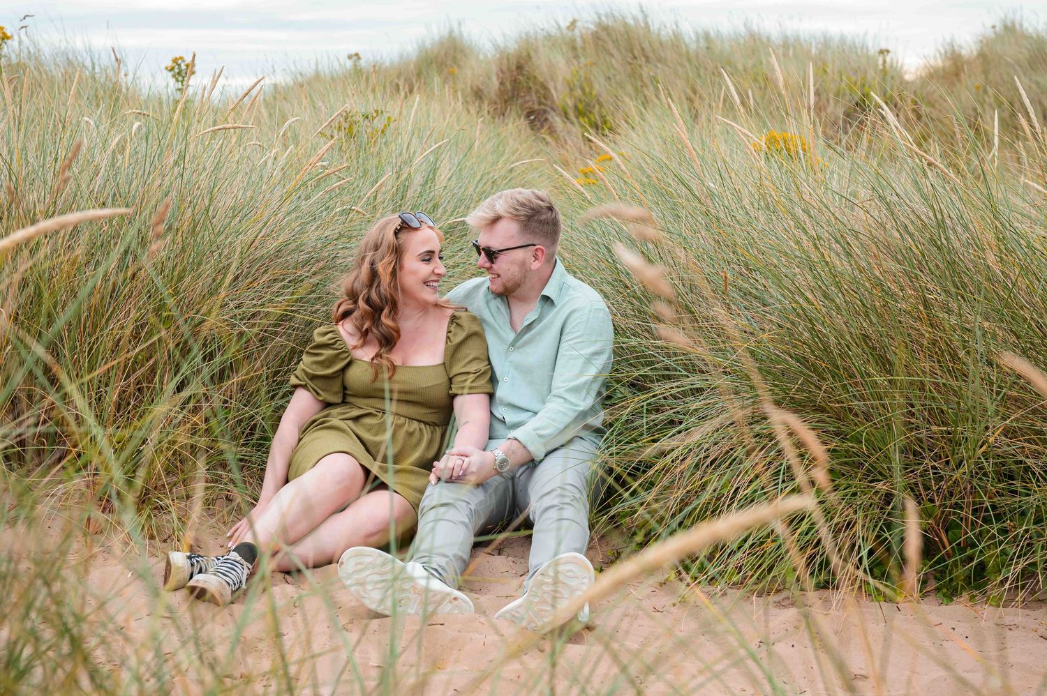 Engaged couple walking along Northumberland beach for engagement photos, North East England