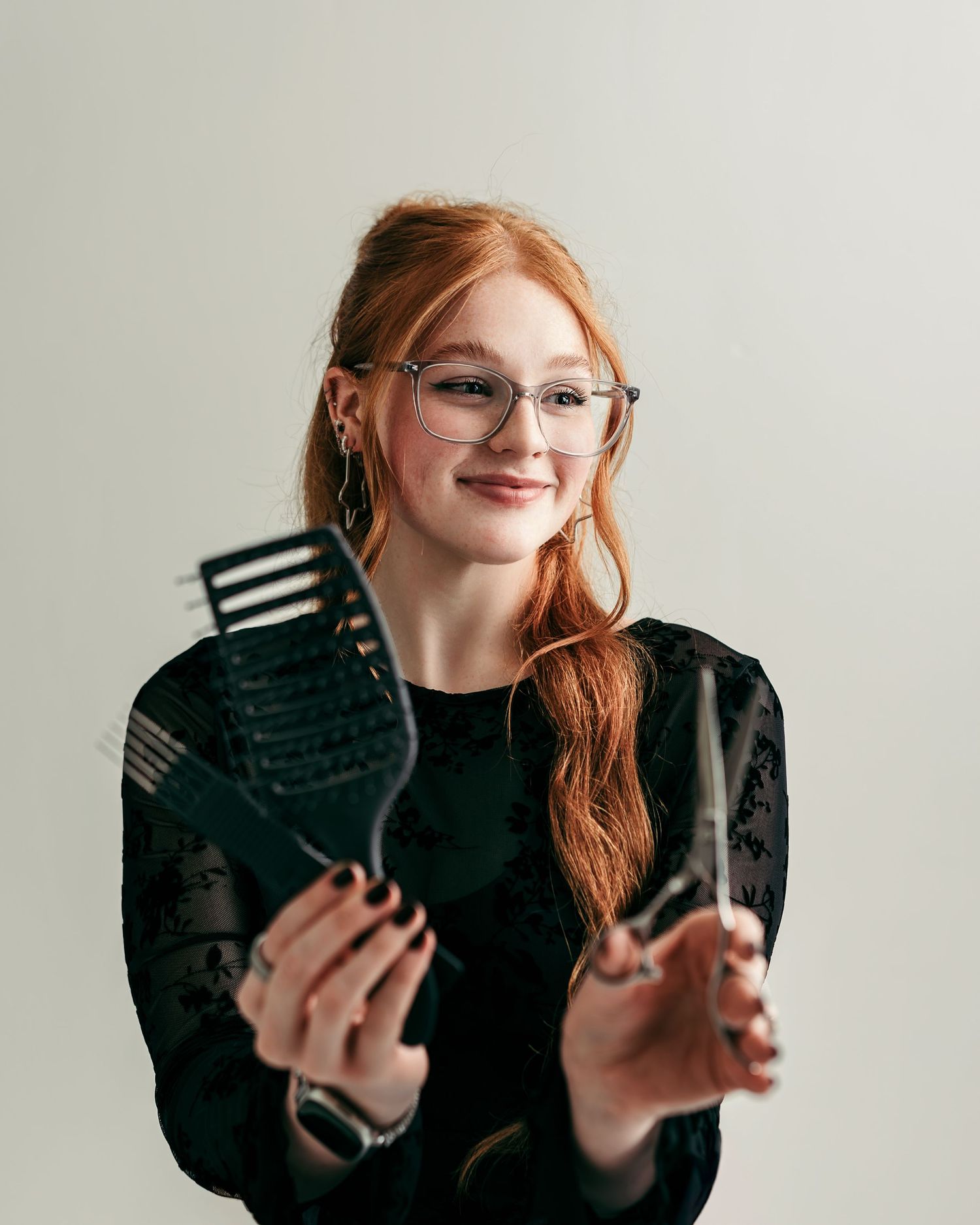 Kansas City bridal hairstylist holding professional hairstyling tools during a branding photography session designed for small businesses