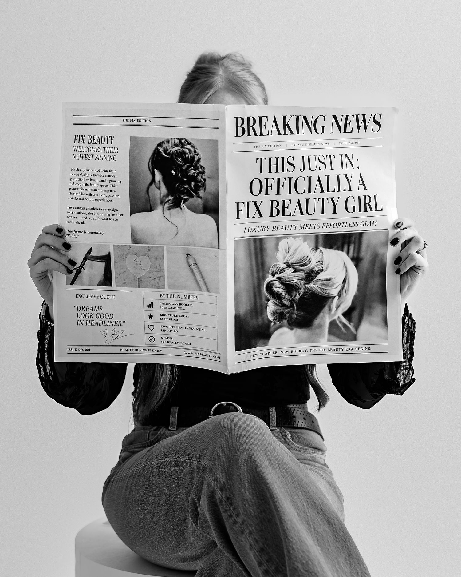 Black and white branding portrait of a Kansas City bridal hairstylist holding a custom newspaper.