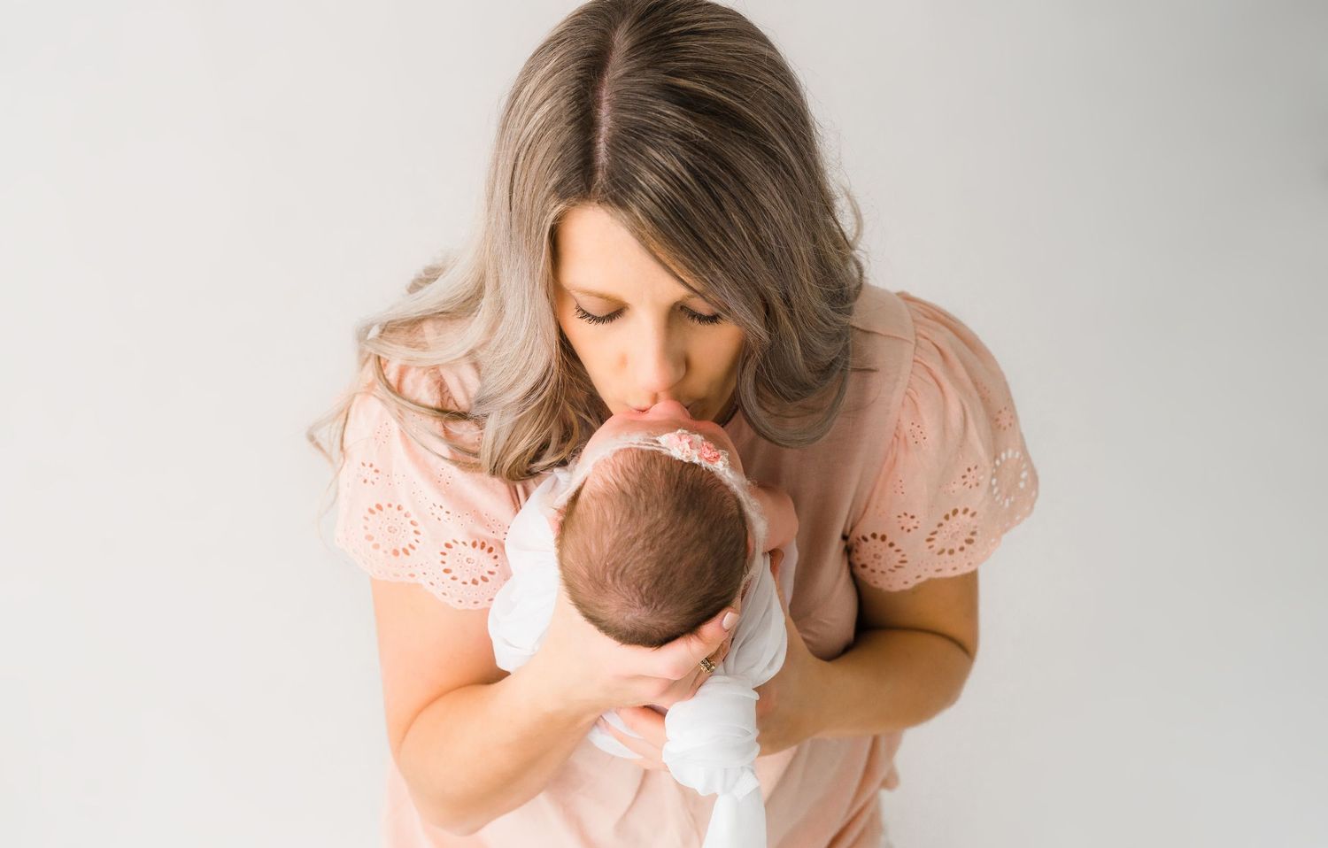 Newborn baby held by mother during studio session Kansas City newborn photographer