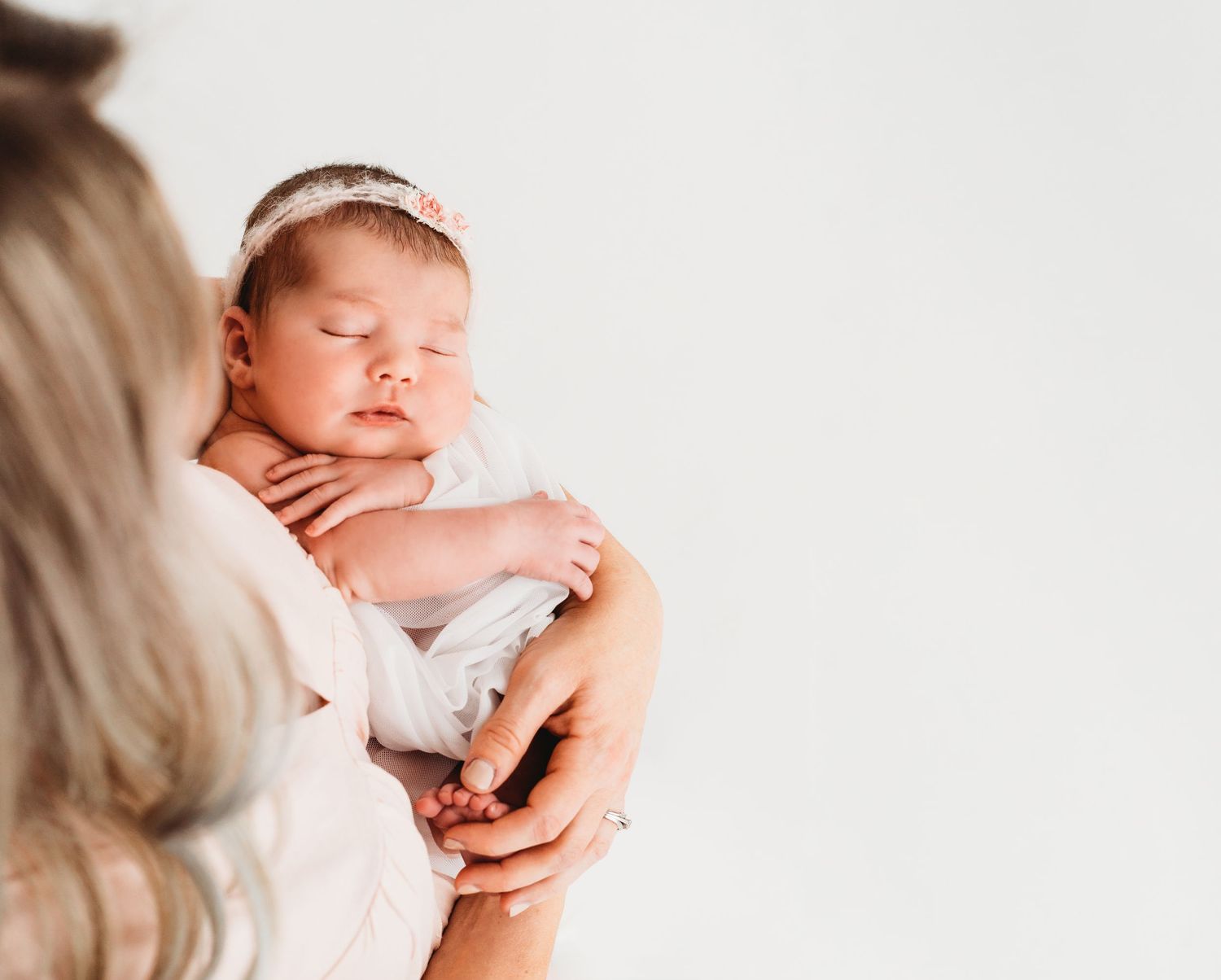 Soft studio newborn portrait of baby swaddled in neutral tones