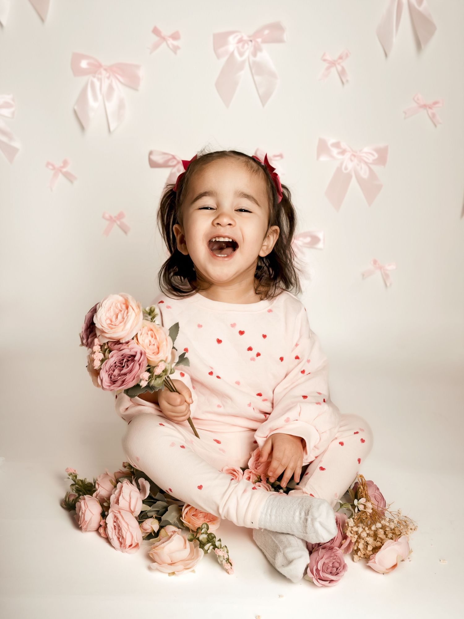 Sweet toddler girl laughing during studio mini session with floral backdrop | Blue Springs and Kansas City children’s photography
