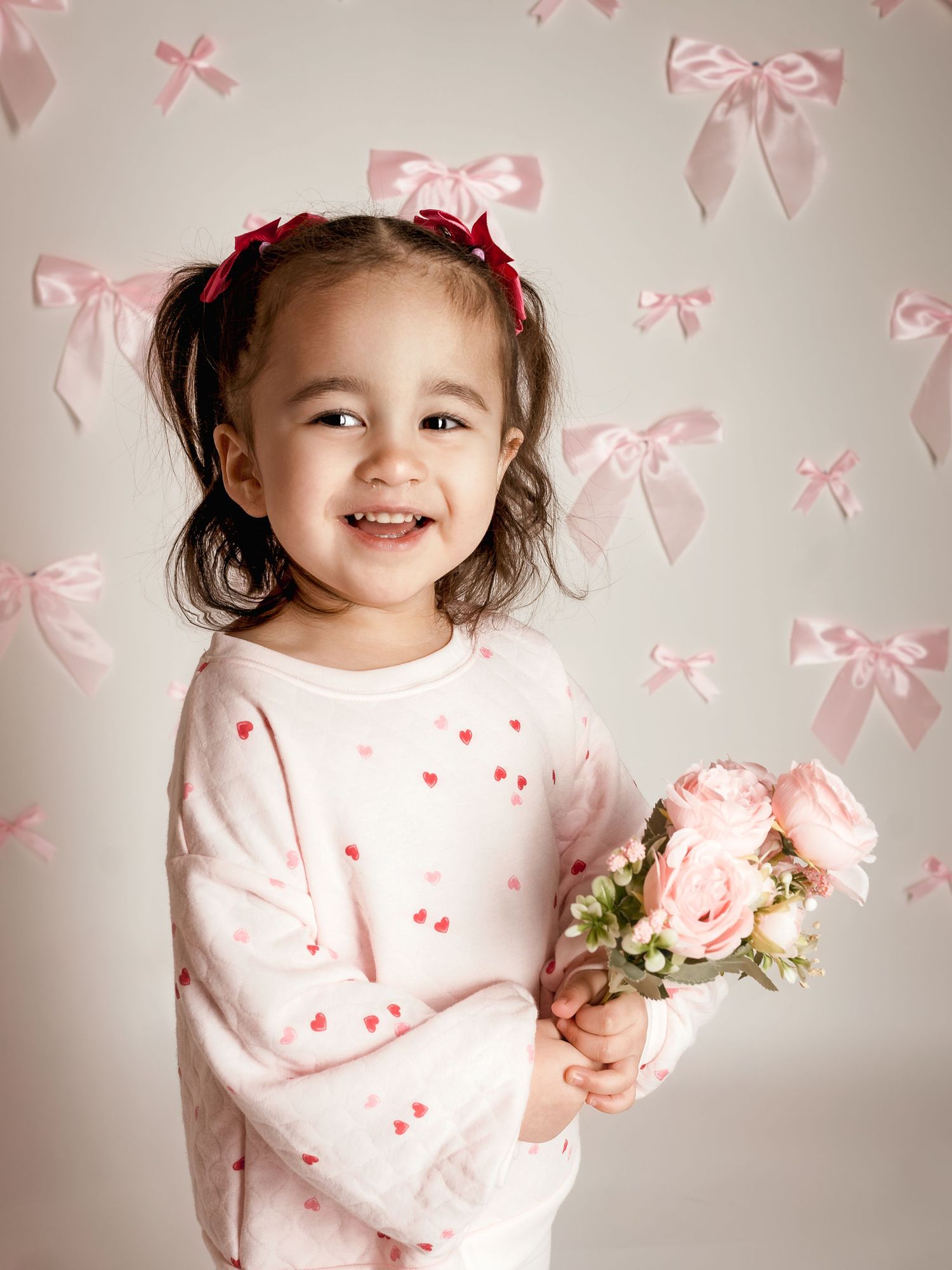 Fine art children’s portrait with soft pink florals and bows | Blue Springs studio photographer serving Kansas City families
