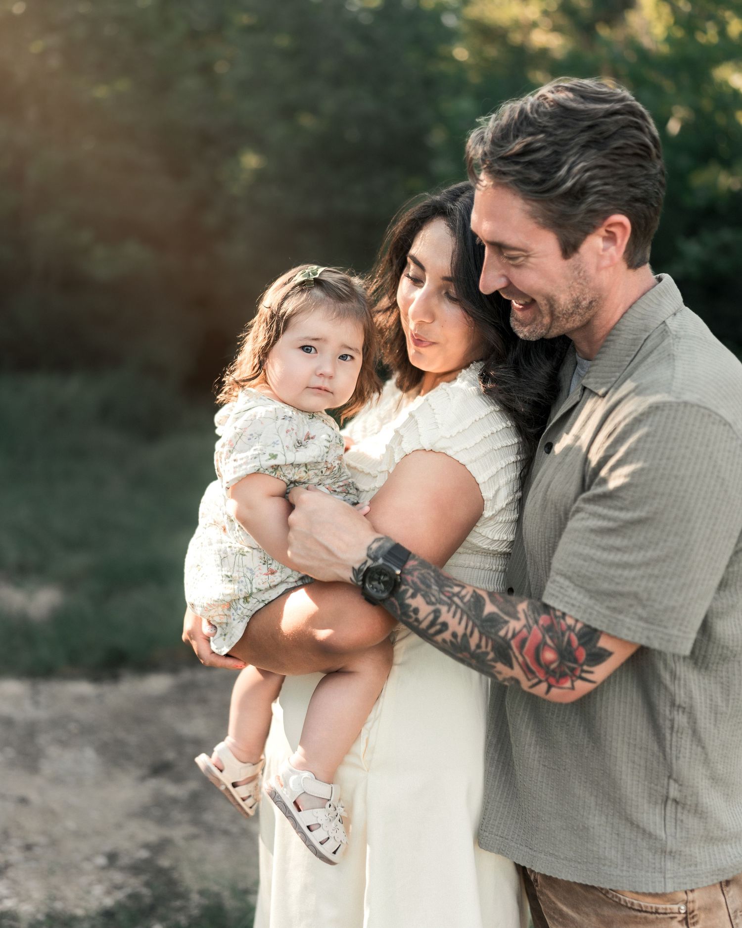 Parents holding their toddler during a golden hour family photography session in Kansas City.