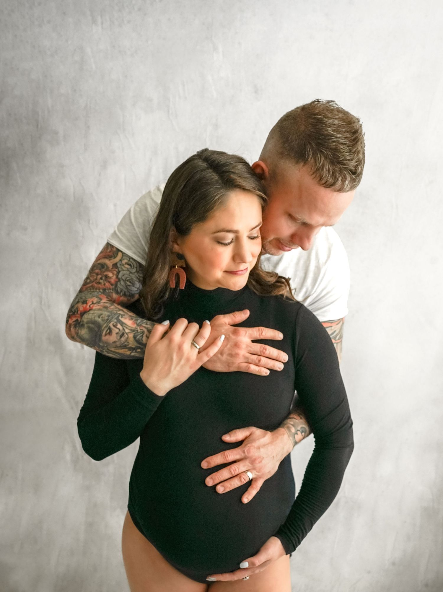 Expecting couple embracing during studio maternity session Kansas City maternity photographer