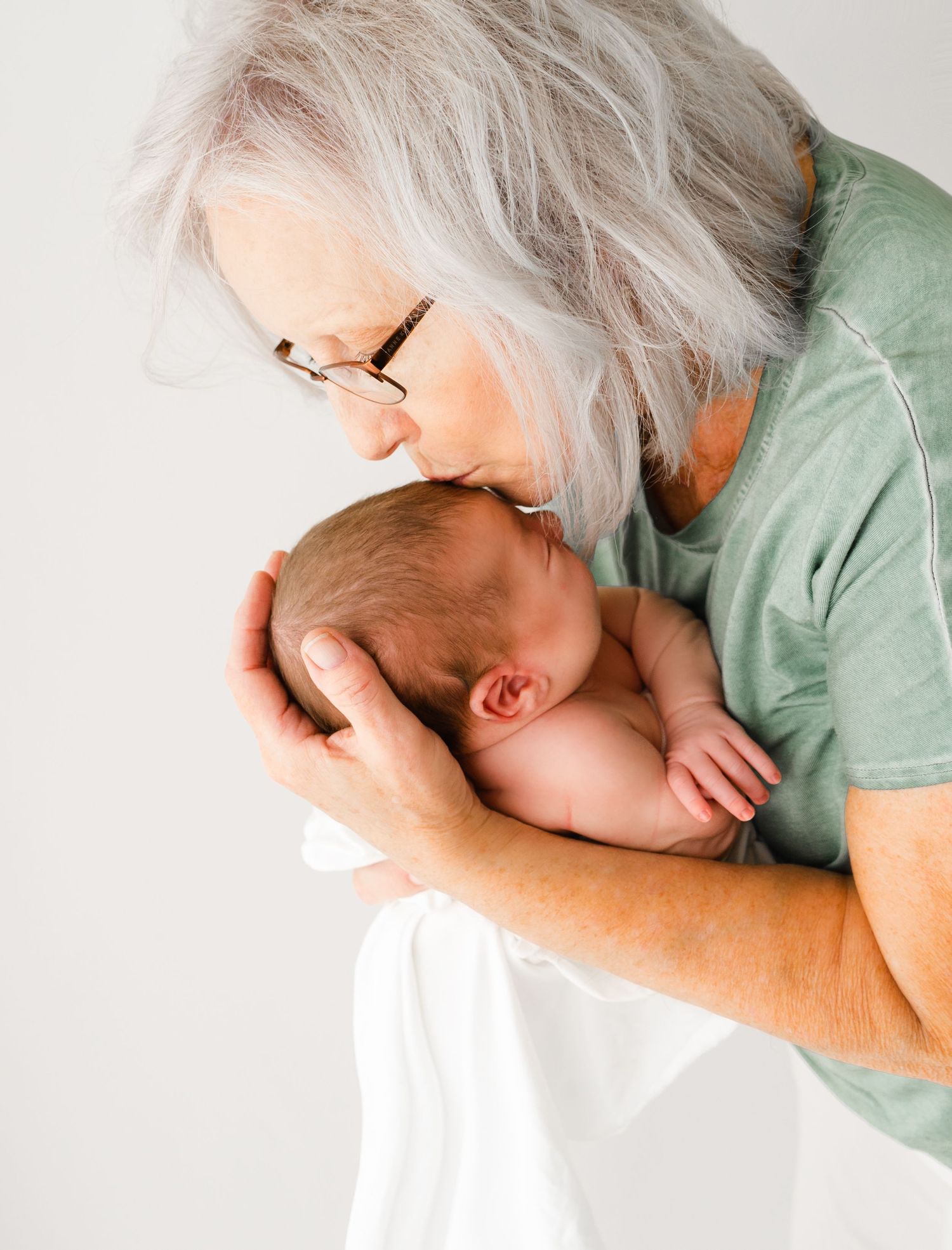 Grandmother holding her newborn grandbaby during studio portrait session Kansas City