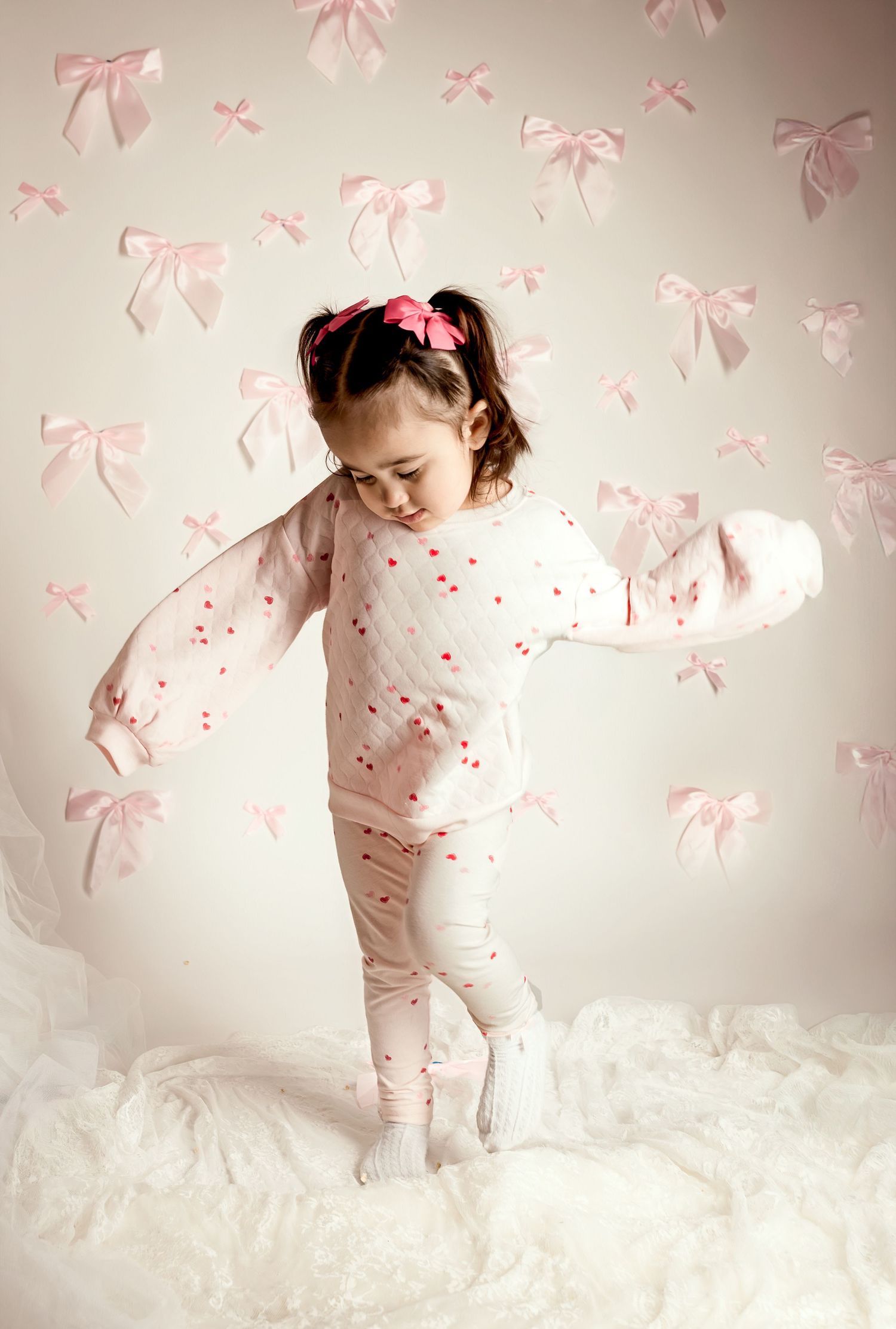 Toddler girl portrait with pink bows and floral backdrop in Blue Springs photography studio | Kansas City children’s photographer