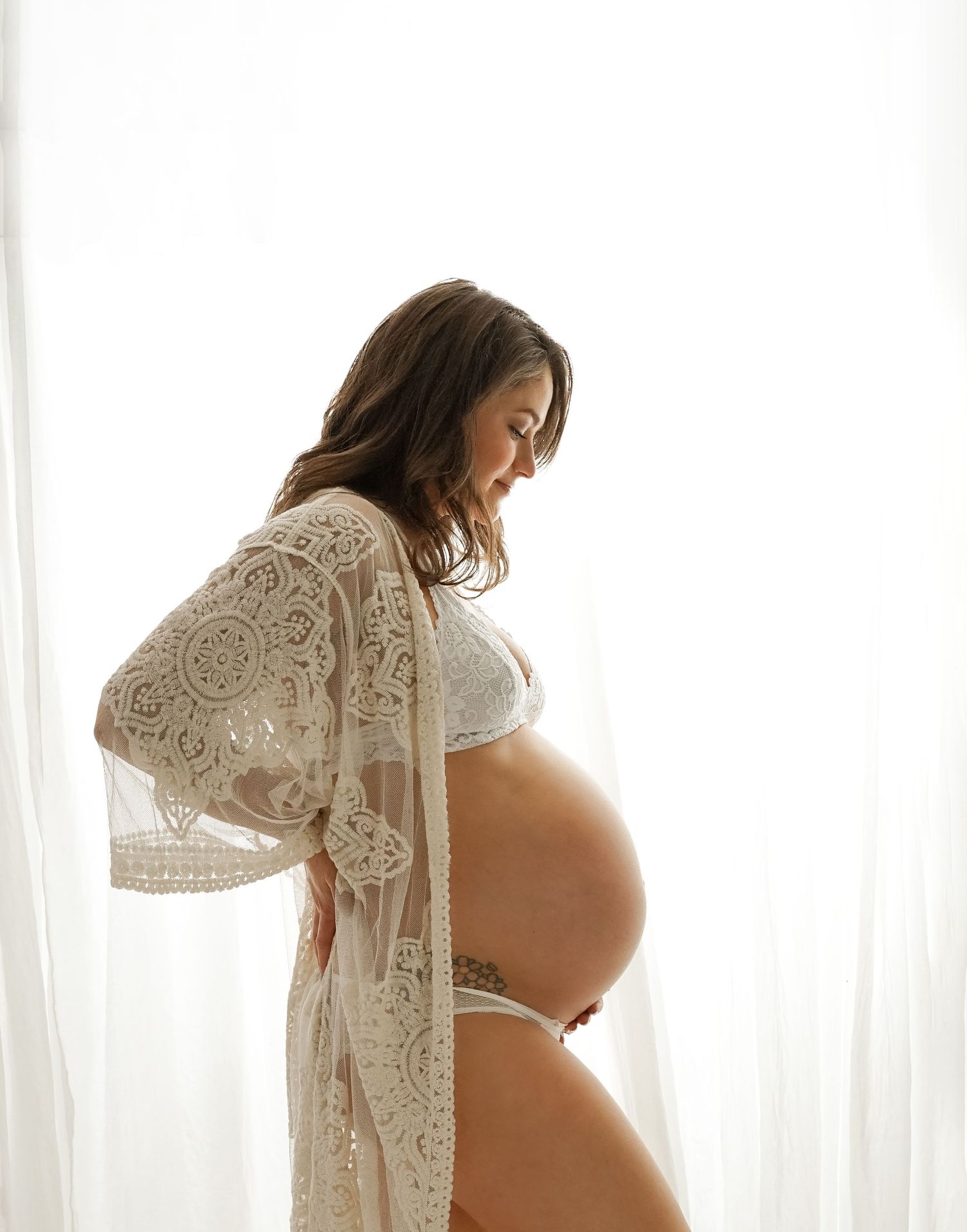 Soft light highlighting pregnancy curves in studio maternity session