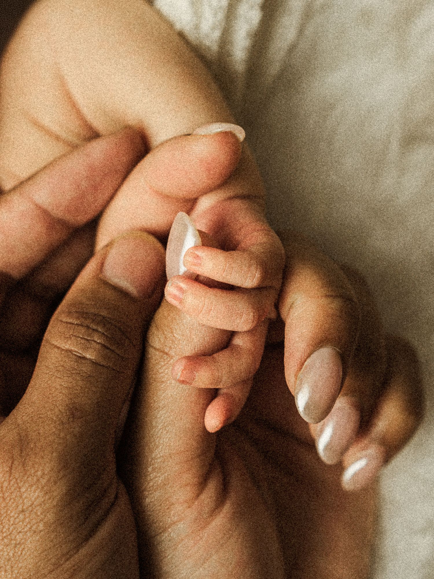close-up of a newborn baby holding a parent’s finger during a Kansas City newborn session