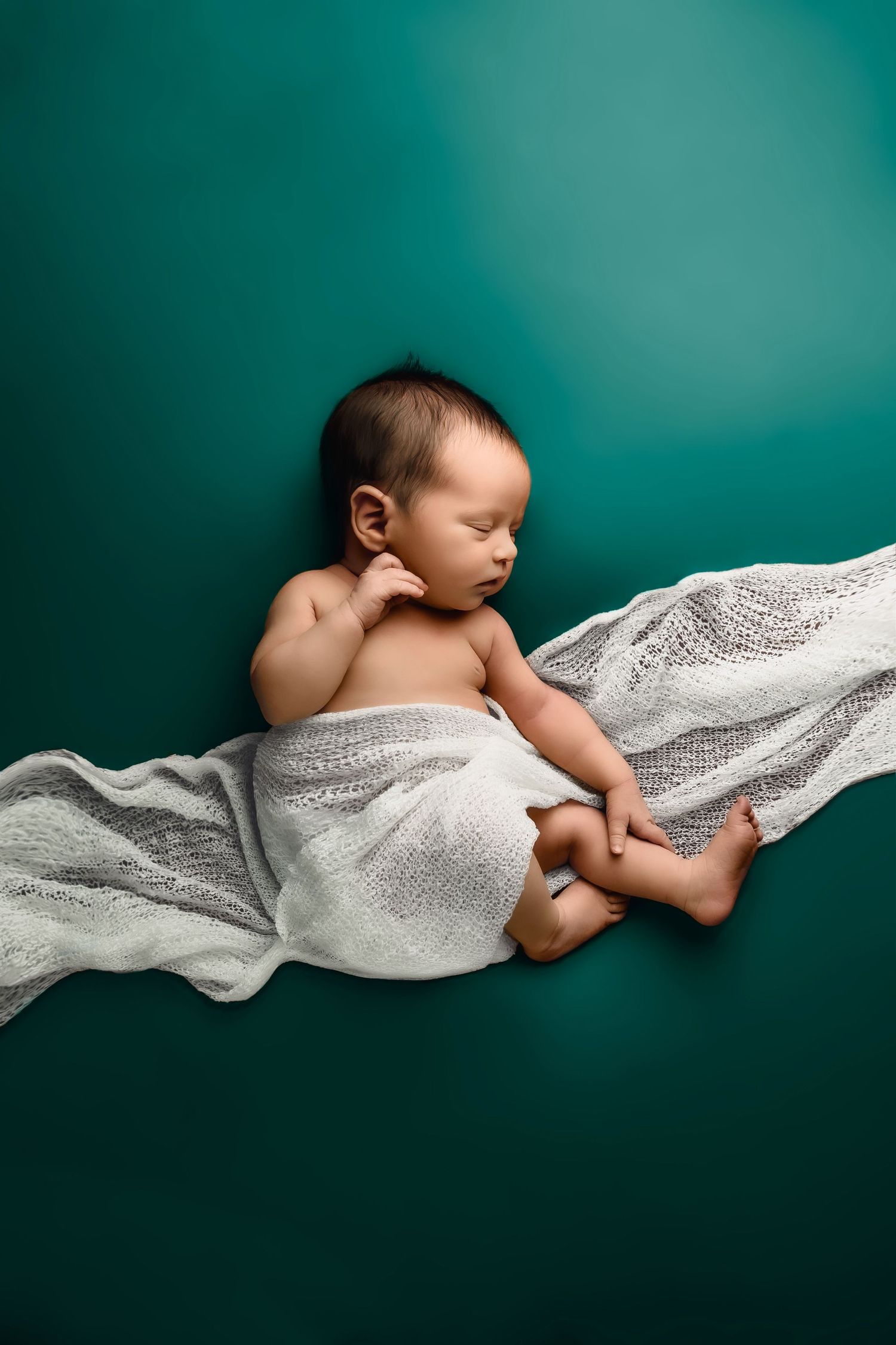 Sleeping newborn posed in studio with minimal styling in Blue Springs Missouri