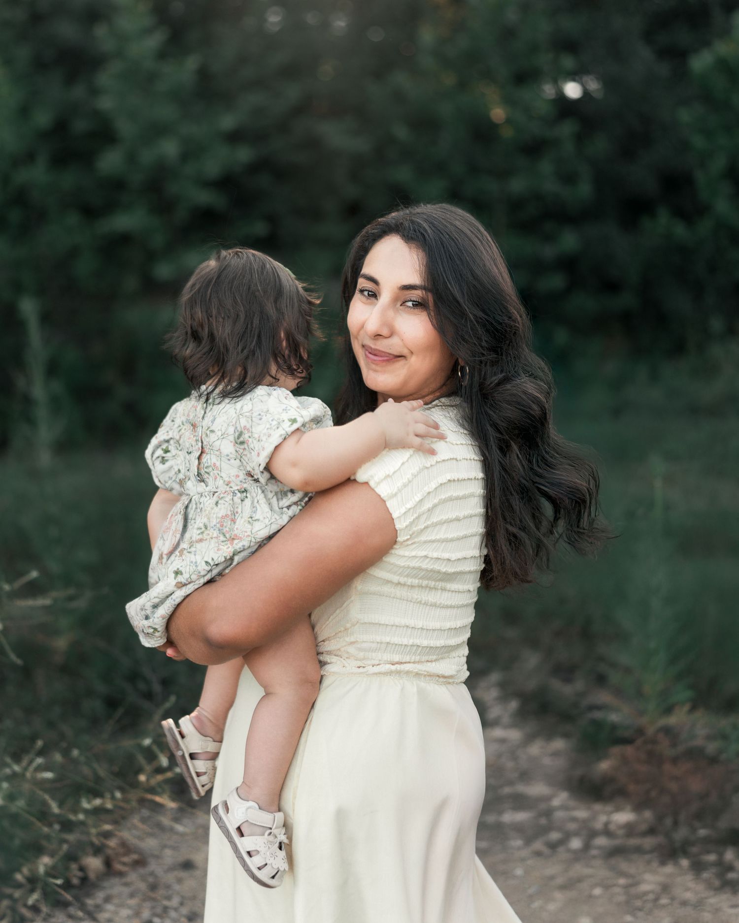 Mother holding her toddler during a peaceful outdoor family photography session in Blue Springs, MO.