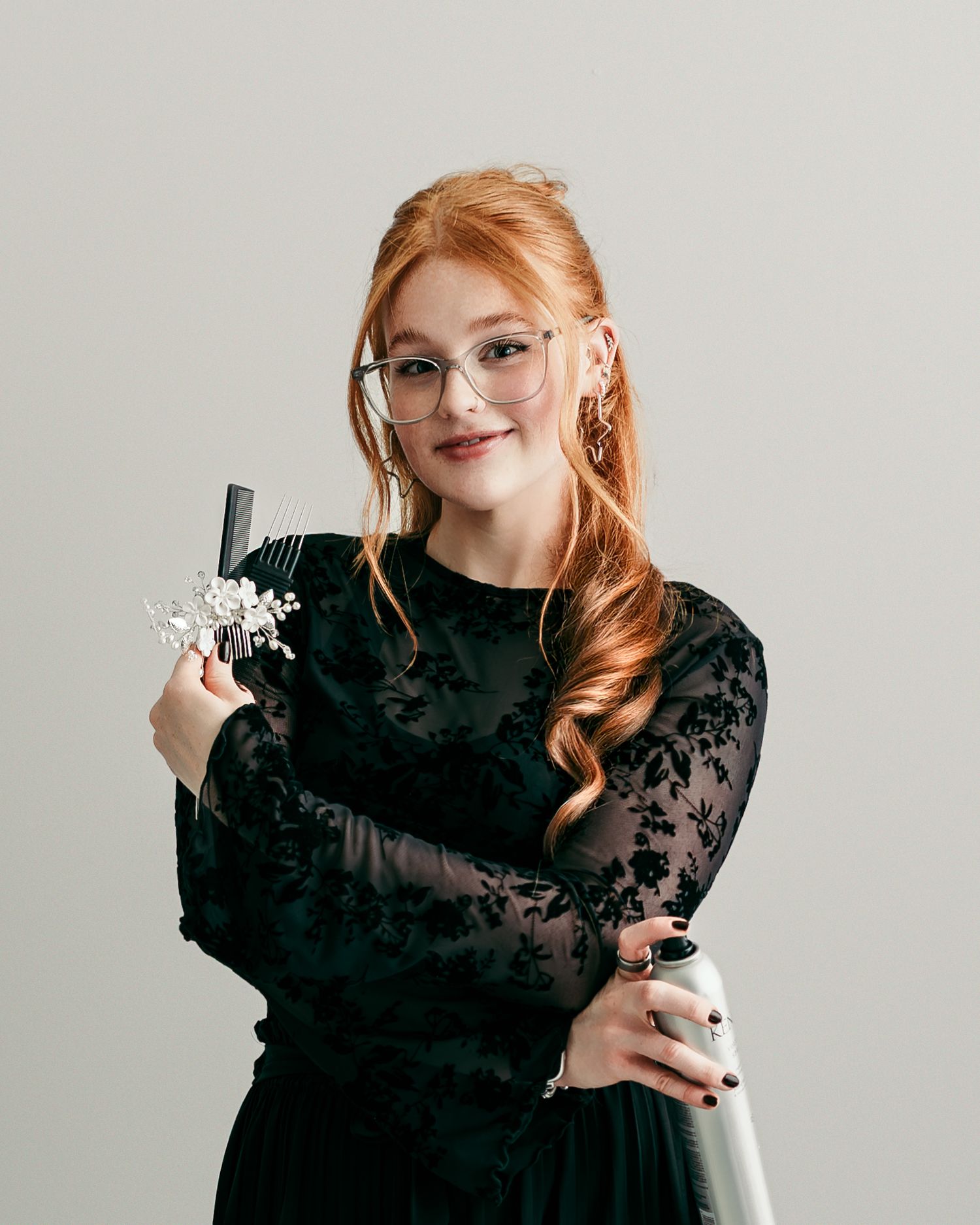 Kansas City bridal hairstylist holding a bridal hair accessory and styling comb during a personal branding photography session in studio.