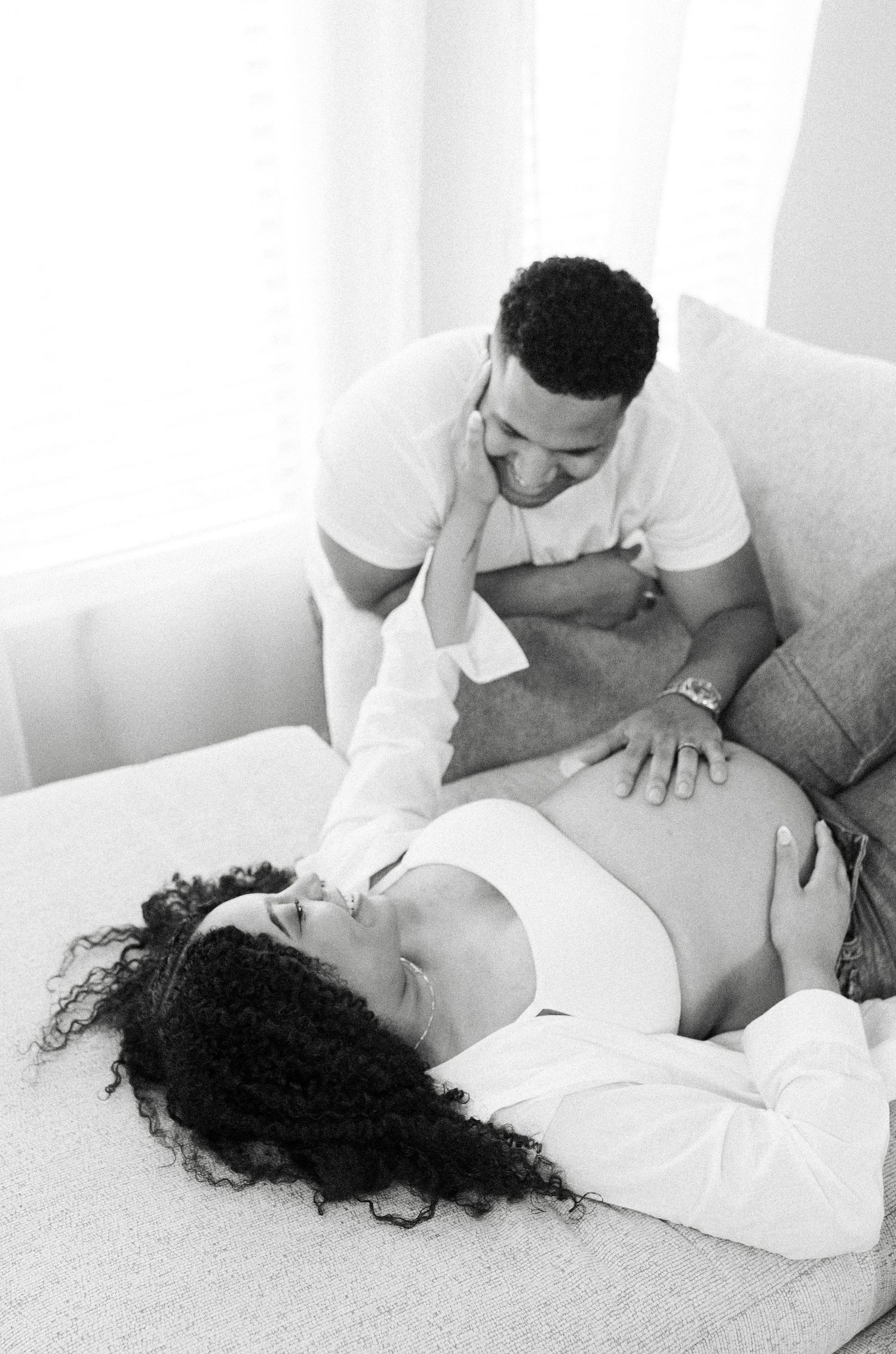 A massage therapist performs a therapeutic back massage treatment on client laying on white massage table at spa.