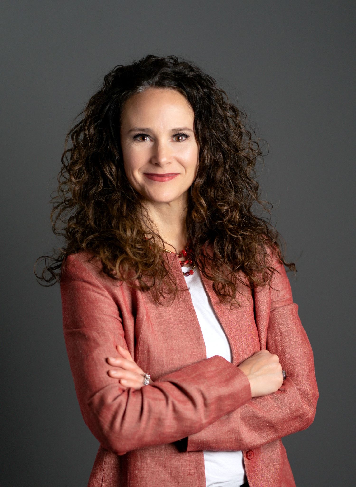 Professional headshot of woman in Kansas City studio with natural expression and neutral background