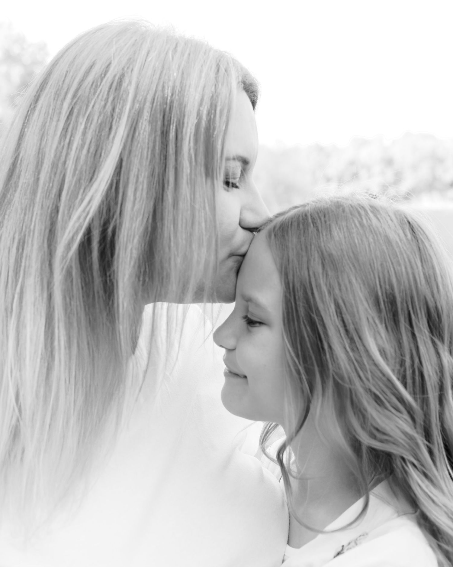 A series of soft black and white profile portraits showing ethereal side views with flowing light hair.