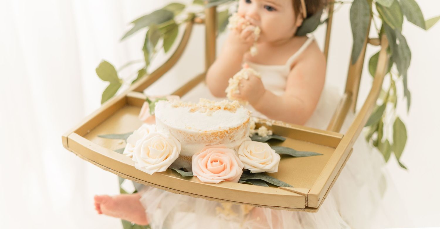 A gold mirrored tray holds delicate pink and white roses next to a eucalyptus branch.