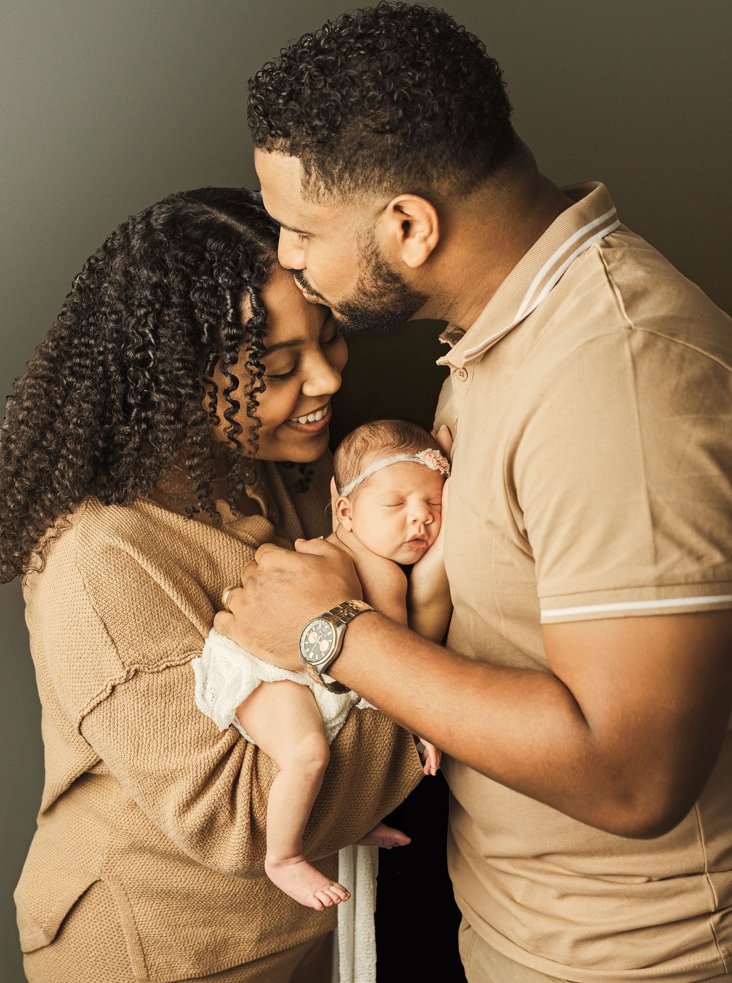 Parents cuddling their newborn during a studio newborn photography session in Kansas City.