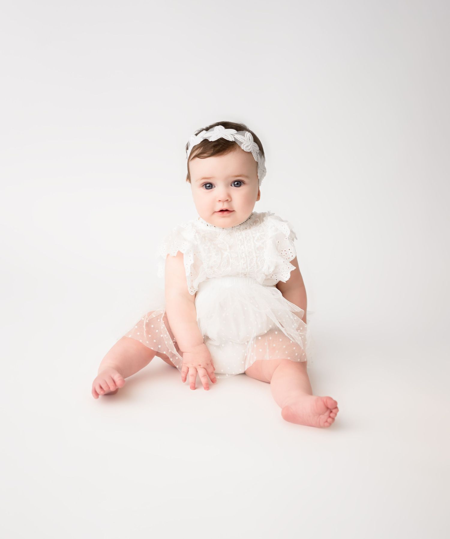 Sitting baby girl during a milestone photography session in Blue Springs, Missouri near Kansas City.