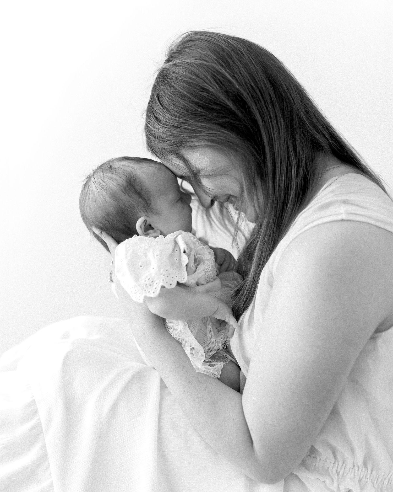 kansas city motherhood photographer black and white mom holding newborn close studio portrait
