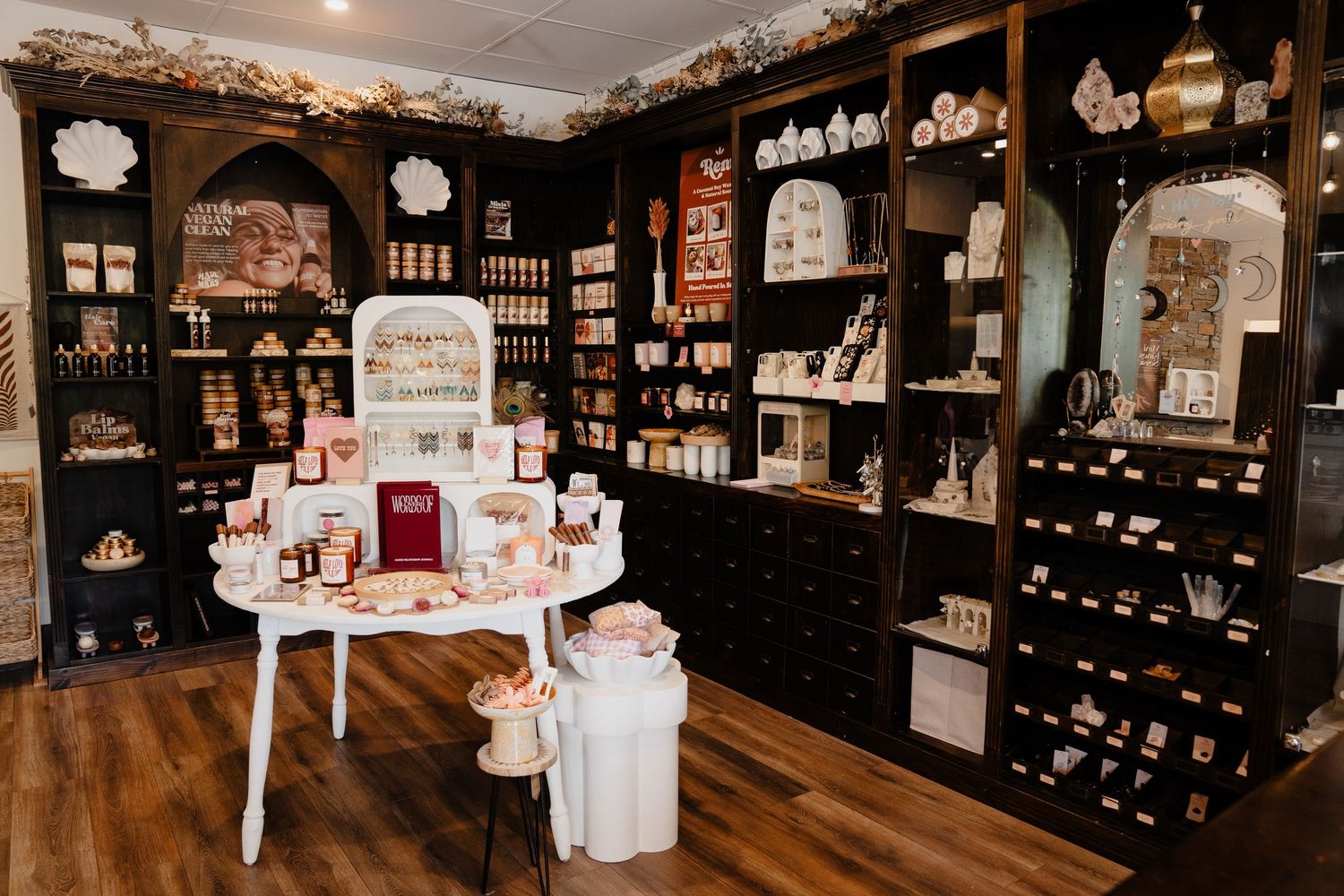 Remi and Mars boutique interior featuring dark shelves stocked with skincare and wellness products.