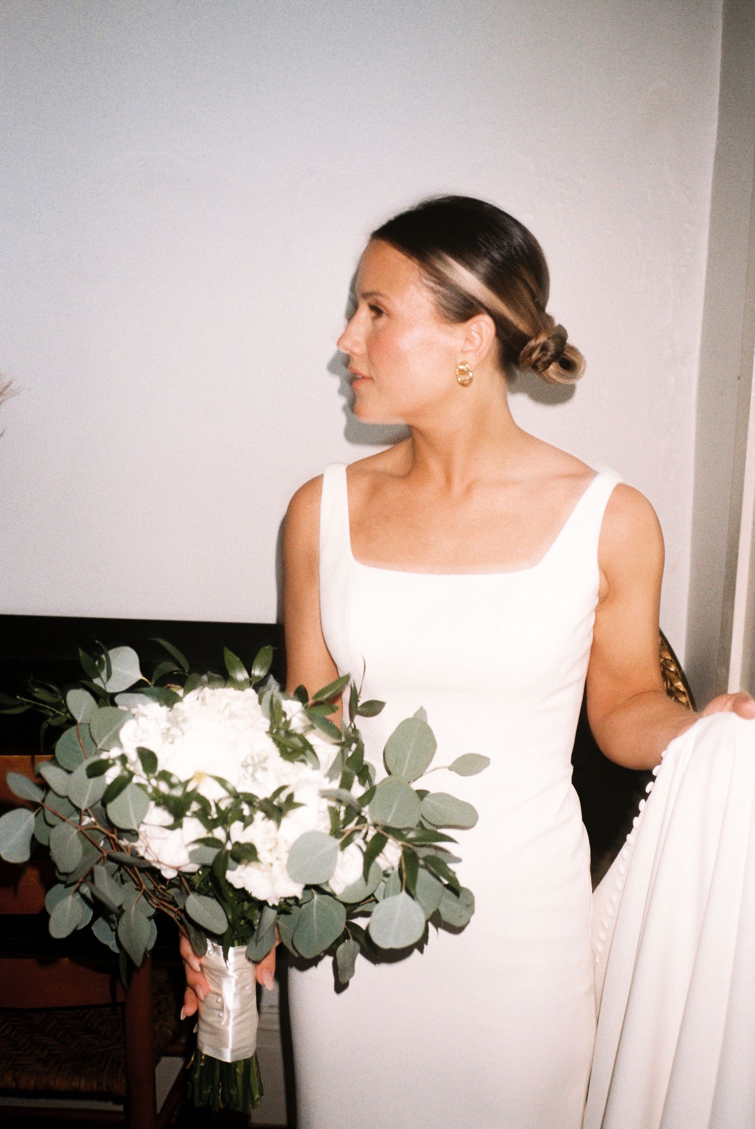 Person in white dress holding eucalyptus bouquet shown in multiple artistic angles.