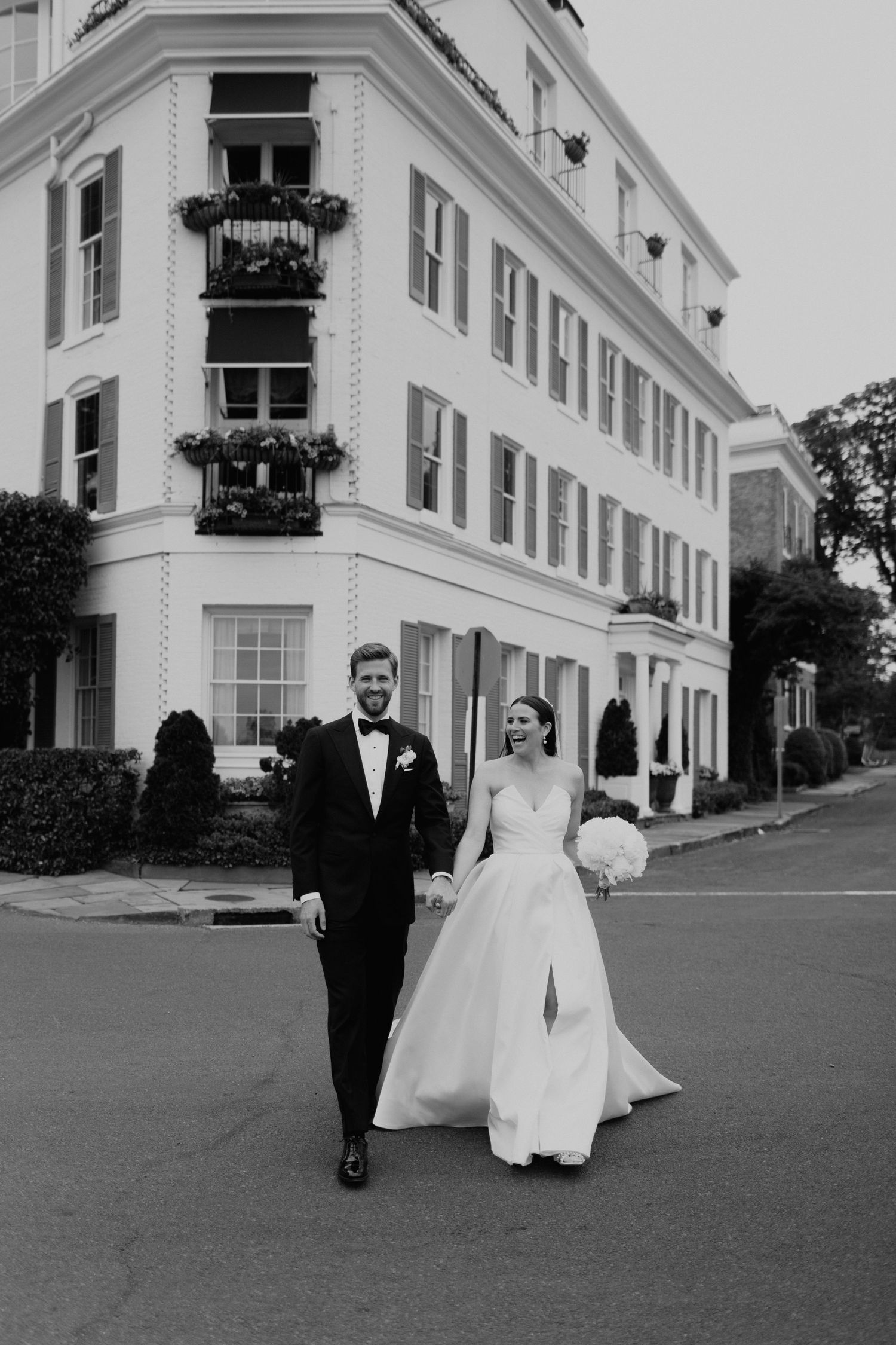 A black and white photo sequence shows a couple in wedding attire walking together on a manicured lawn near elegant buildings in Fairfield.