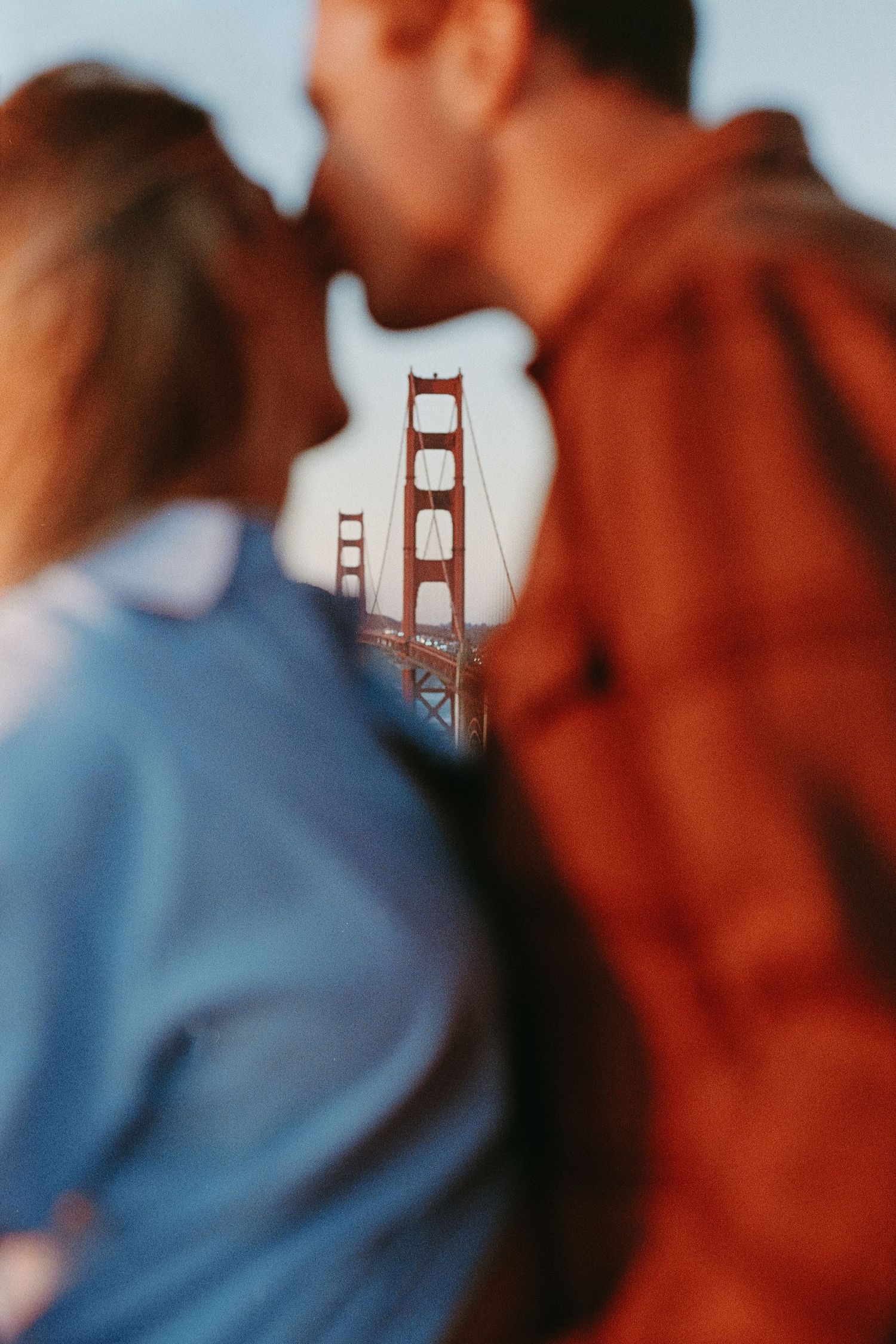Blurred silhouettes against blue sky with Golden Gate Bridge visible in background in San Francisco, CA.
