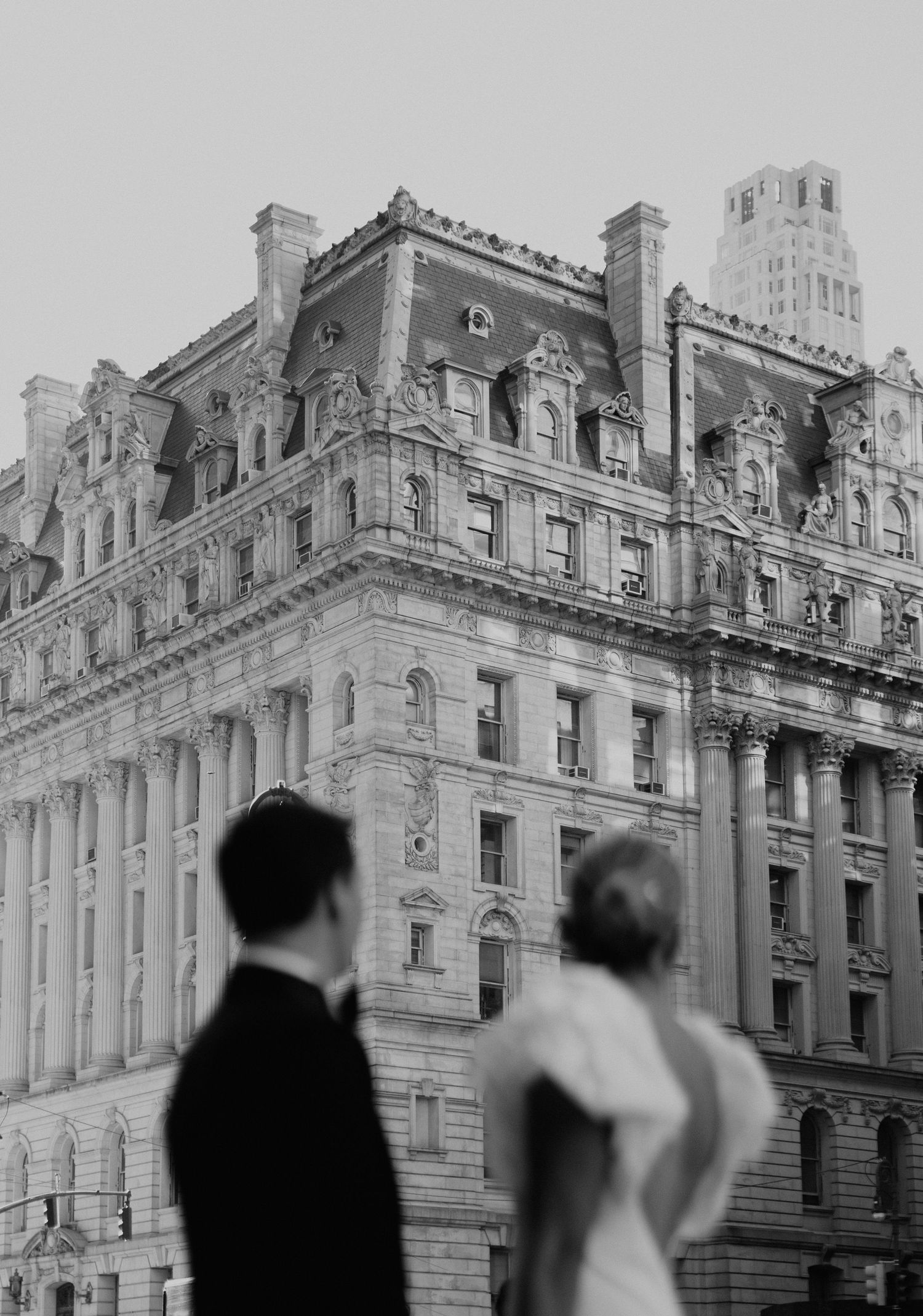 Black and white photograph of an ornate classical building facade with architectural details in Manhattan, New York City.