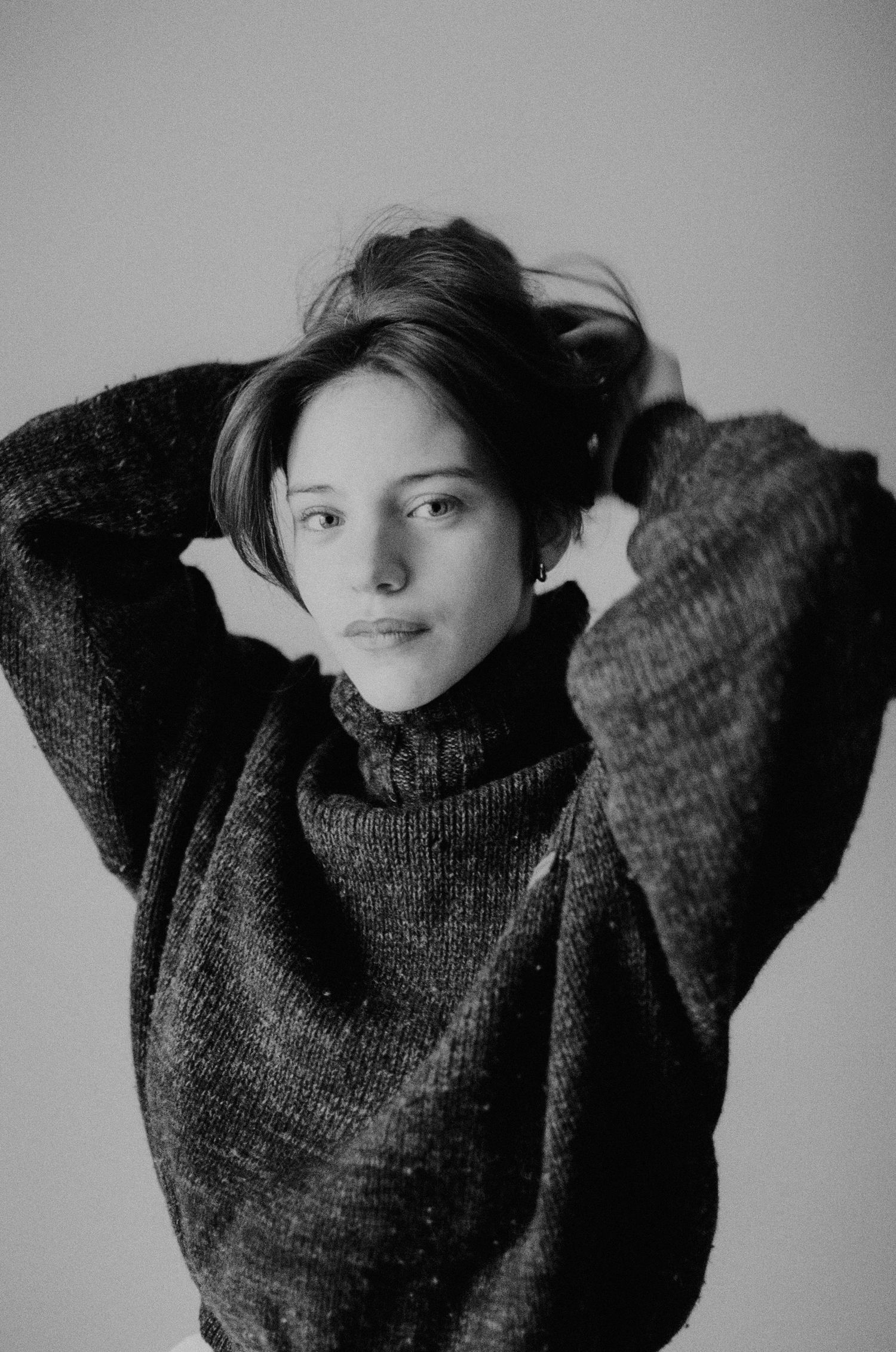 Black and white portrait series showing movement in chunky knit sweater.