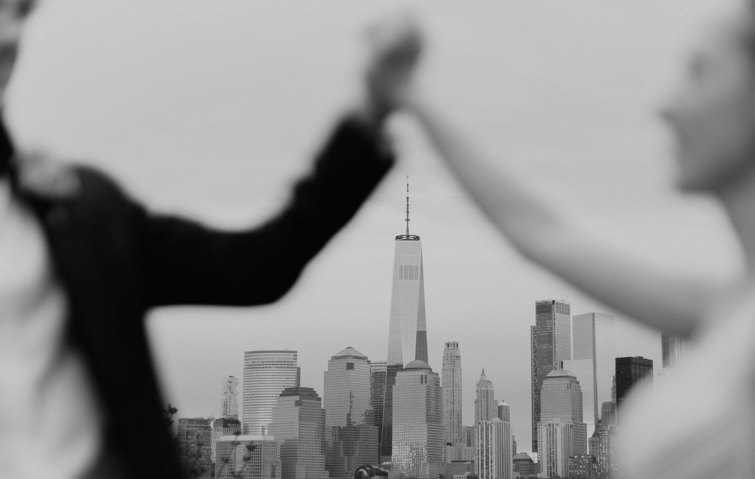New York City skyline silhouetted against a dramatic sky in black and white.