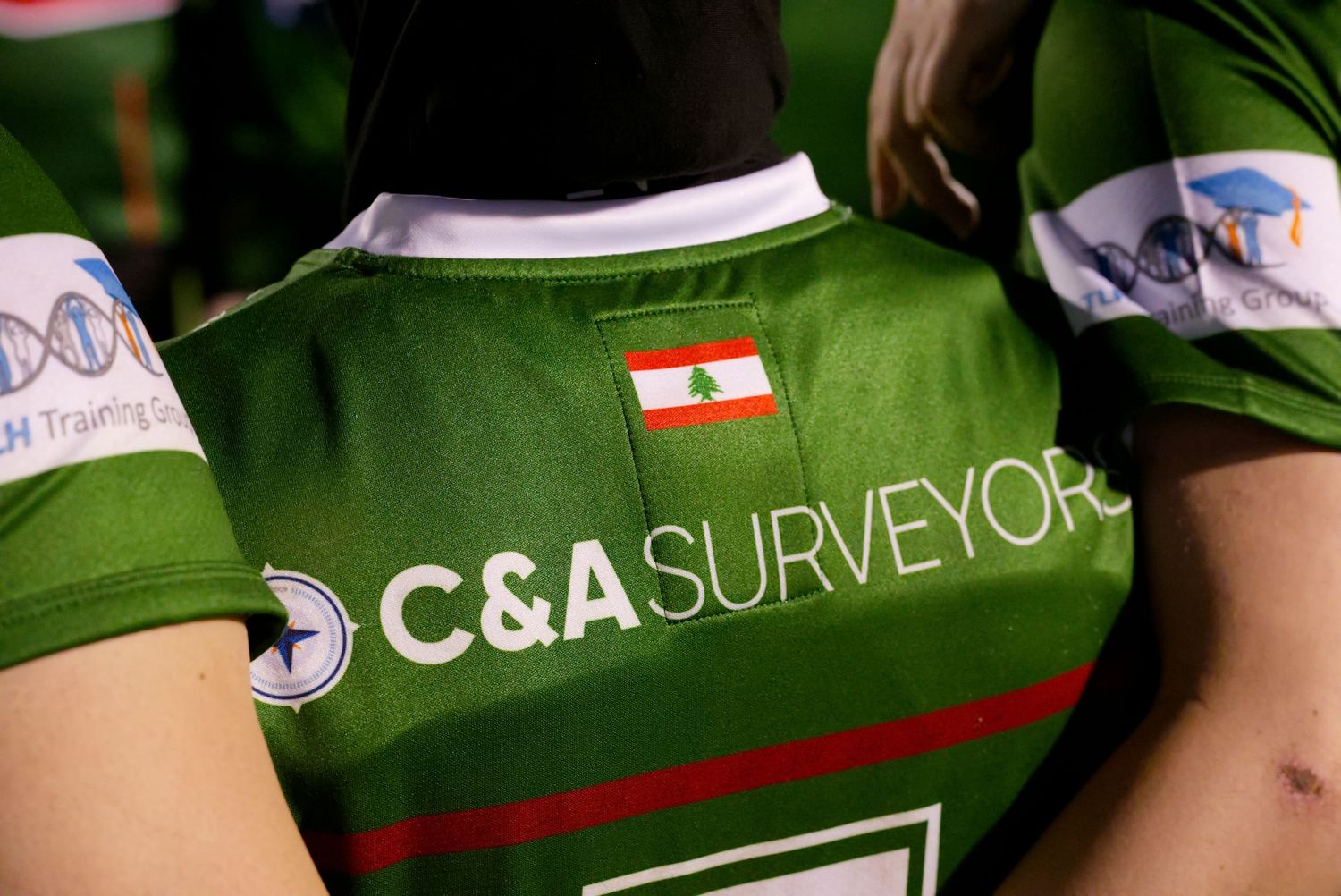 Green rugby jersey with C&A Surveyors sponsor and Lebanese flag badge on the back.