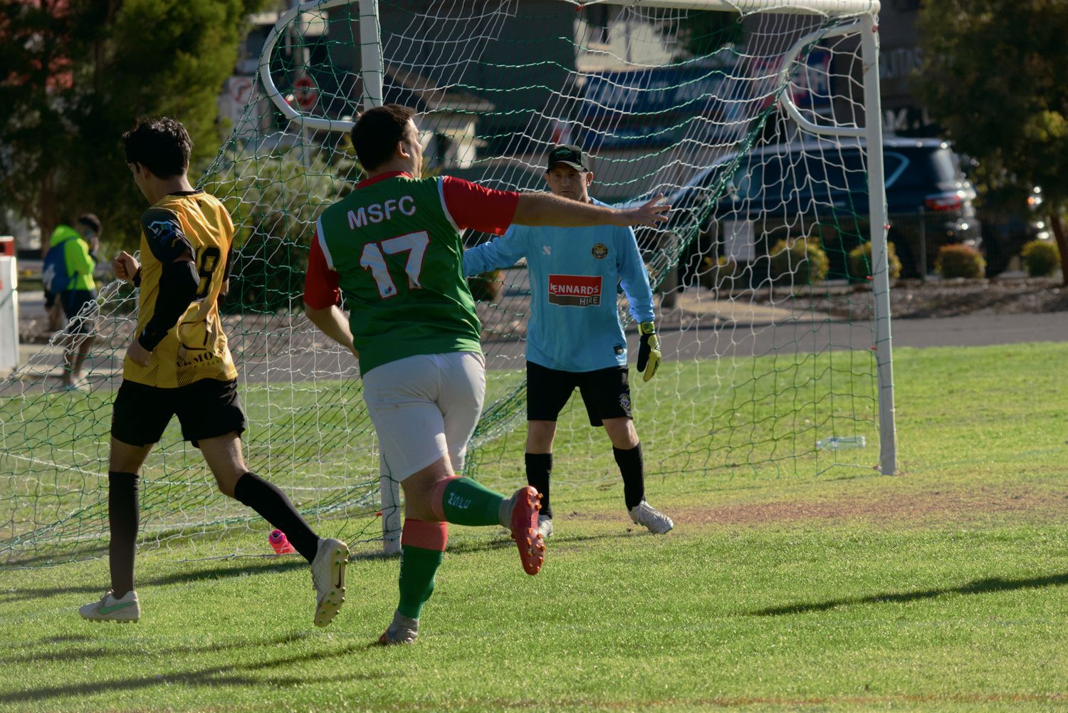 MSFC player number 17 scores a goal past the goalkeeper in a sunny outdoor soccer match.