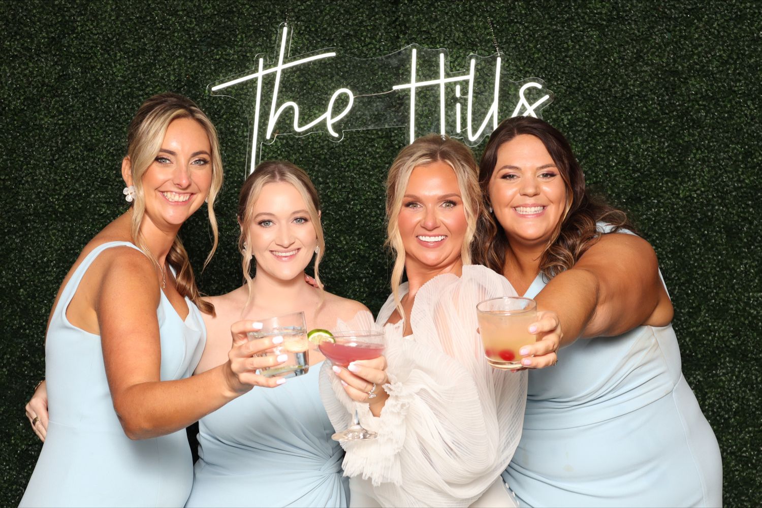 Four guests hold up cocktails in photo booth. Wedding at White Hall Annapolis