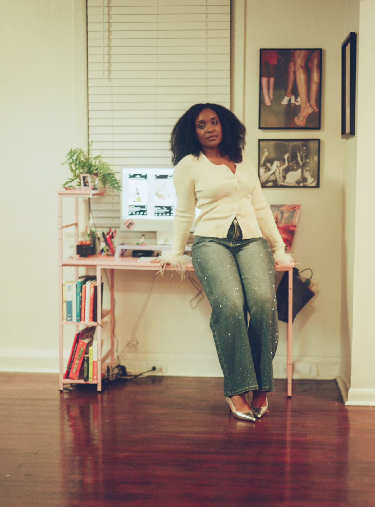A series of four progressive photos showing someone seated on a wooden floor against white walls with artwork.