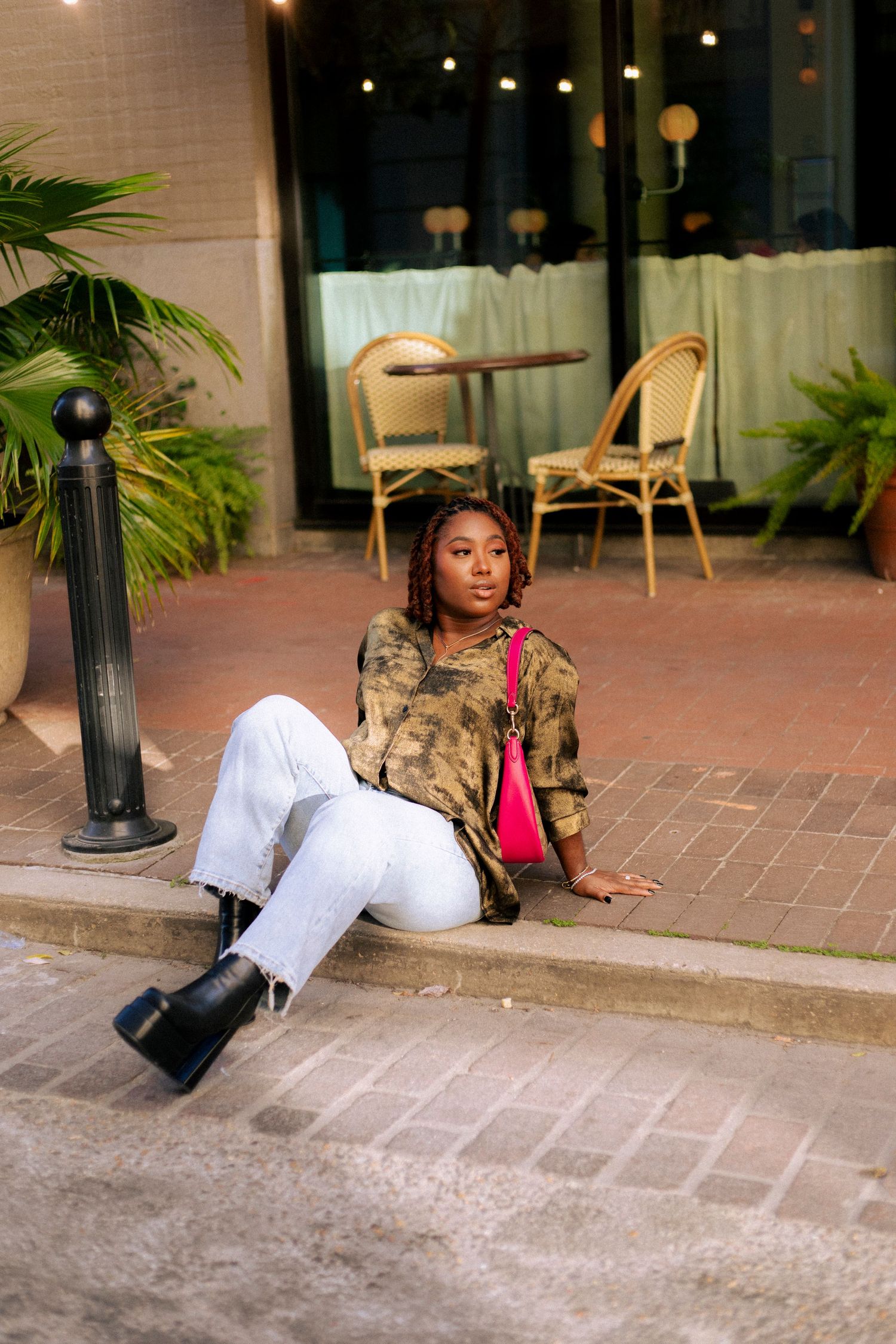 A person in a white outfit and camouflage jacket poses on brick pavement in a series of artistic shots.