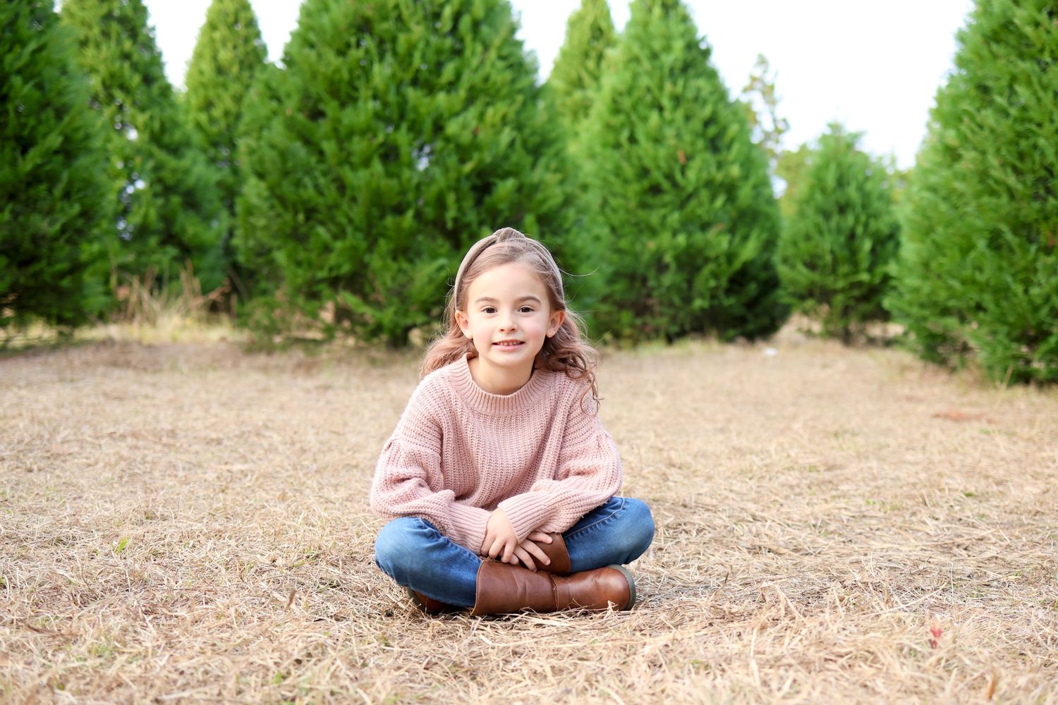 Portrait of a young girl sitting at a Christmas tree farm