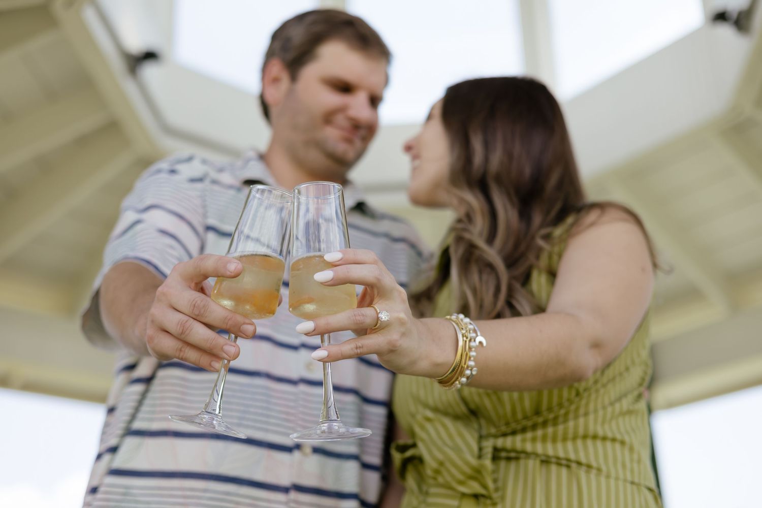 a newly engaged couple make a toast and look at each other