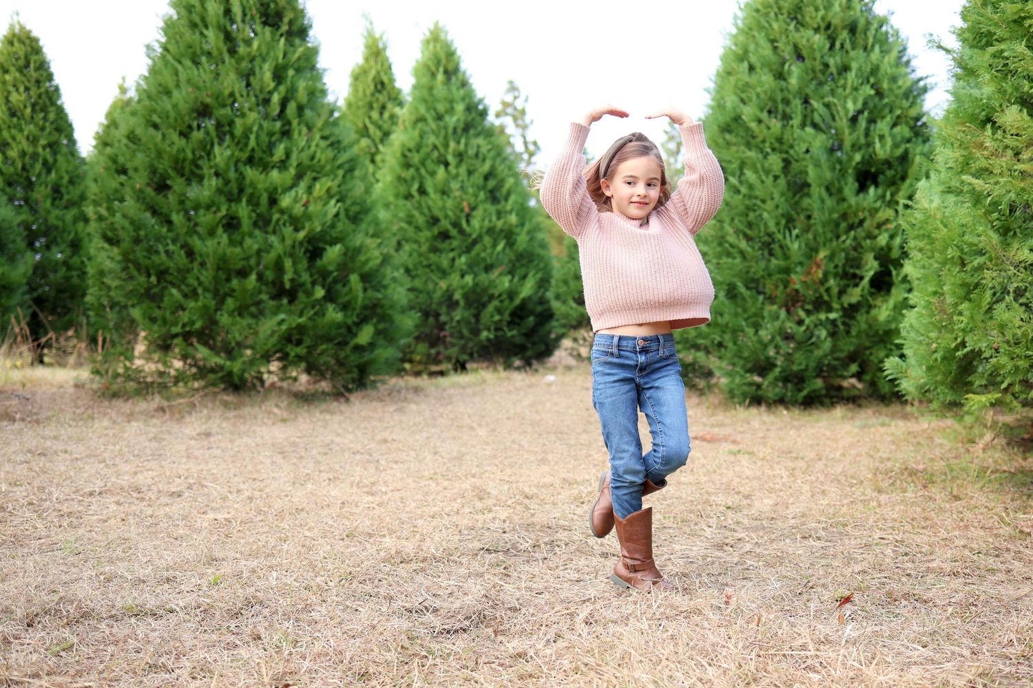 portrait of a young girl dancing on a Christmas tree farm