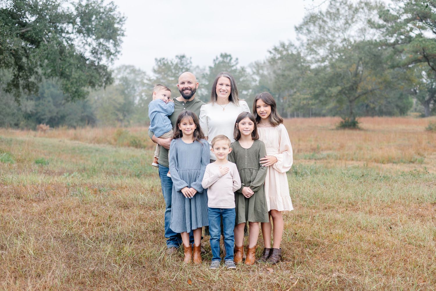 a family posing in a misty field