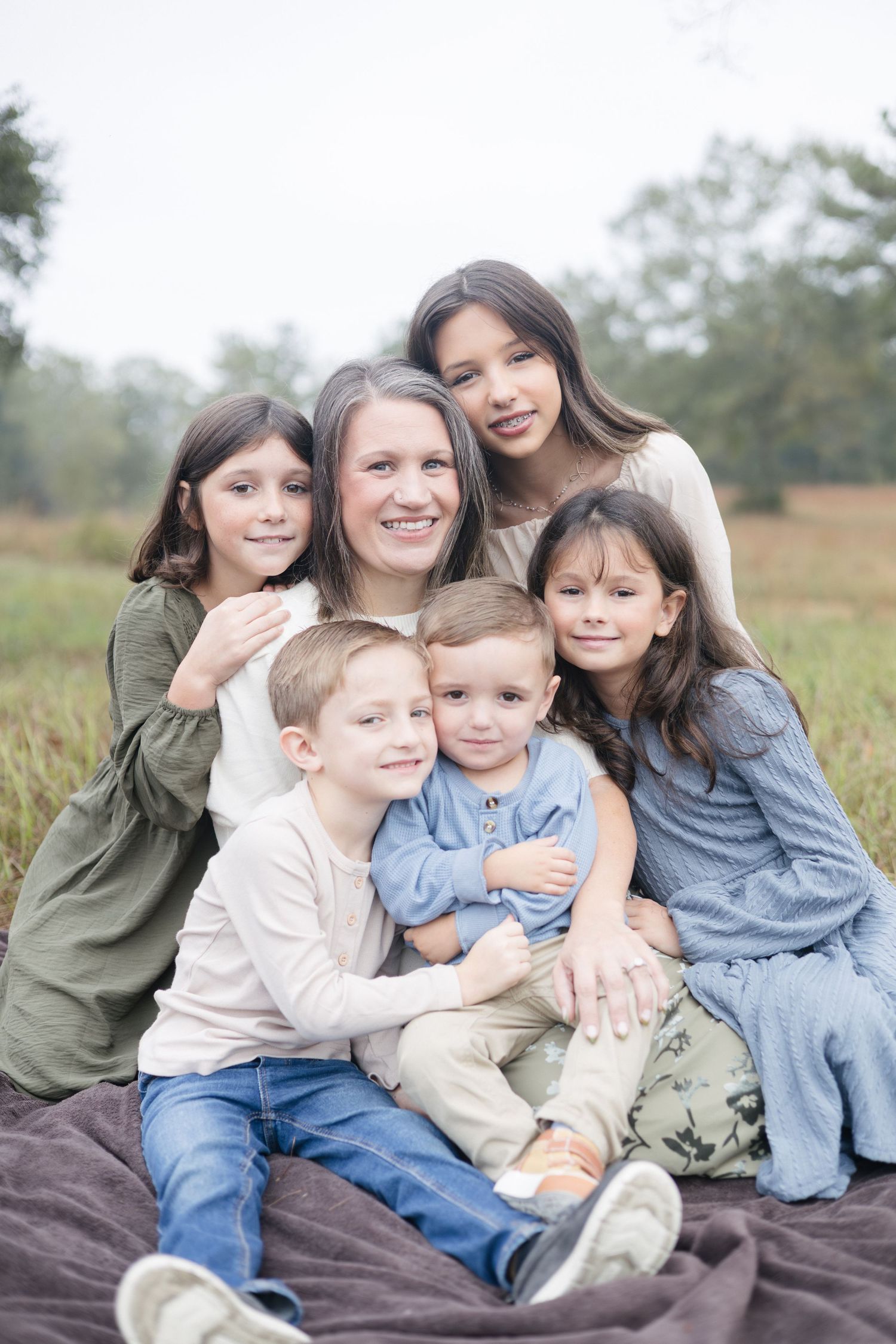 A mother and her five children around her in a field